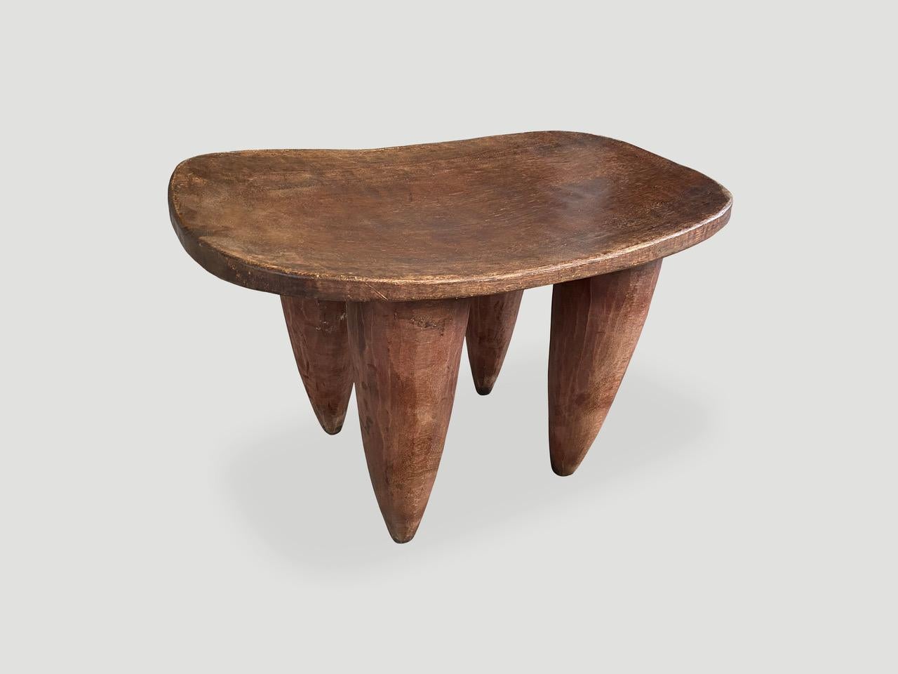 Beautiful antique side table or small bench, hand carved from a single block of wood with beautiful patina. Both sculptural and usable. Shown with cone style legs. We only source the best. 

This side table or stool was sourced in the spirit of