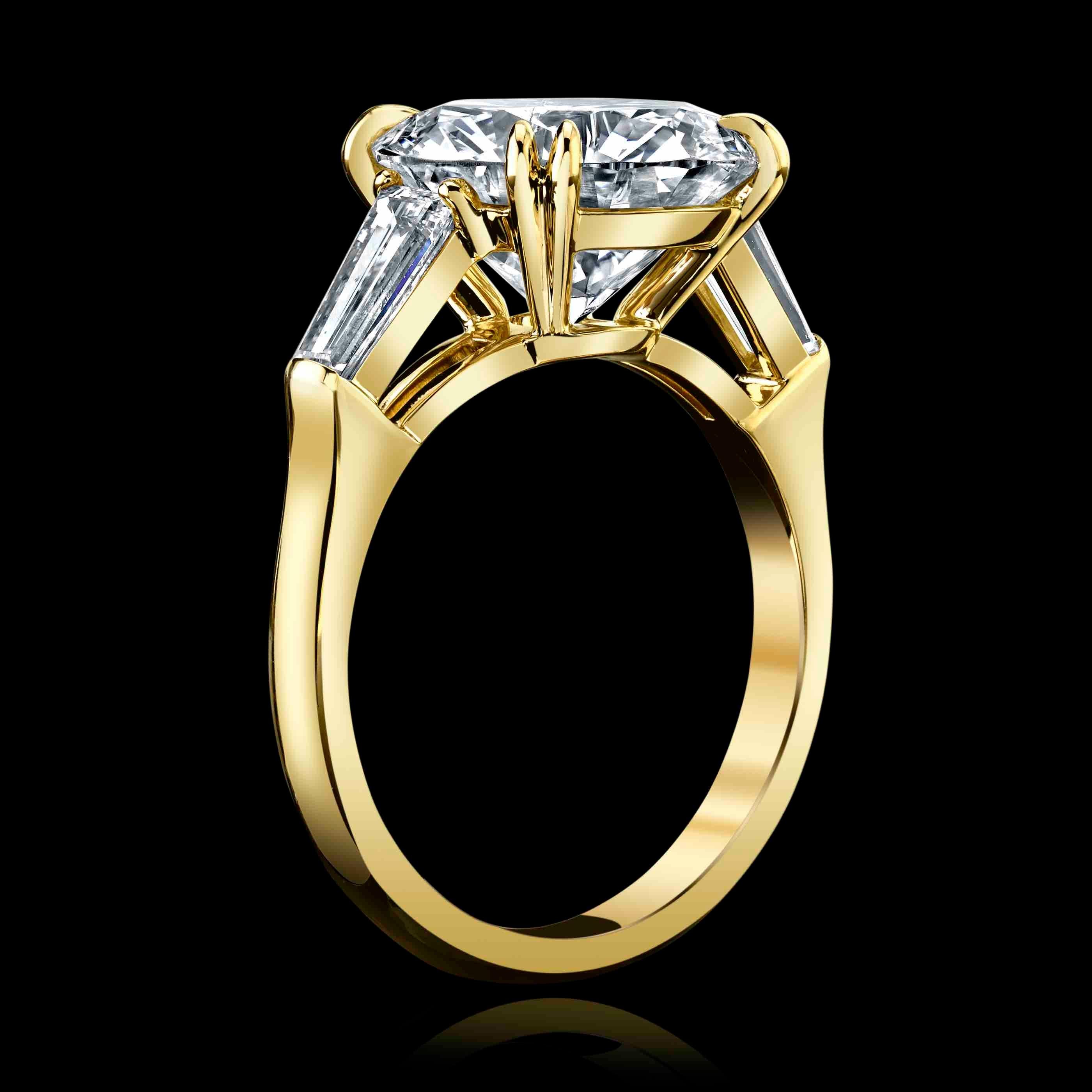 This gorgeous 5.17ct Round brilliant diamond is J color and VVS2 clarity.
It is set in a classic 18K Yellow Gold setting with 2 side baguette diamonds , J color, VVS2 clarity = 0.75ctttw
The center diamond is GIA certified #5211491314

