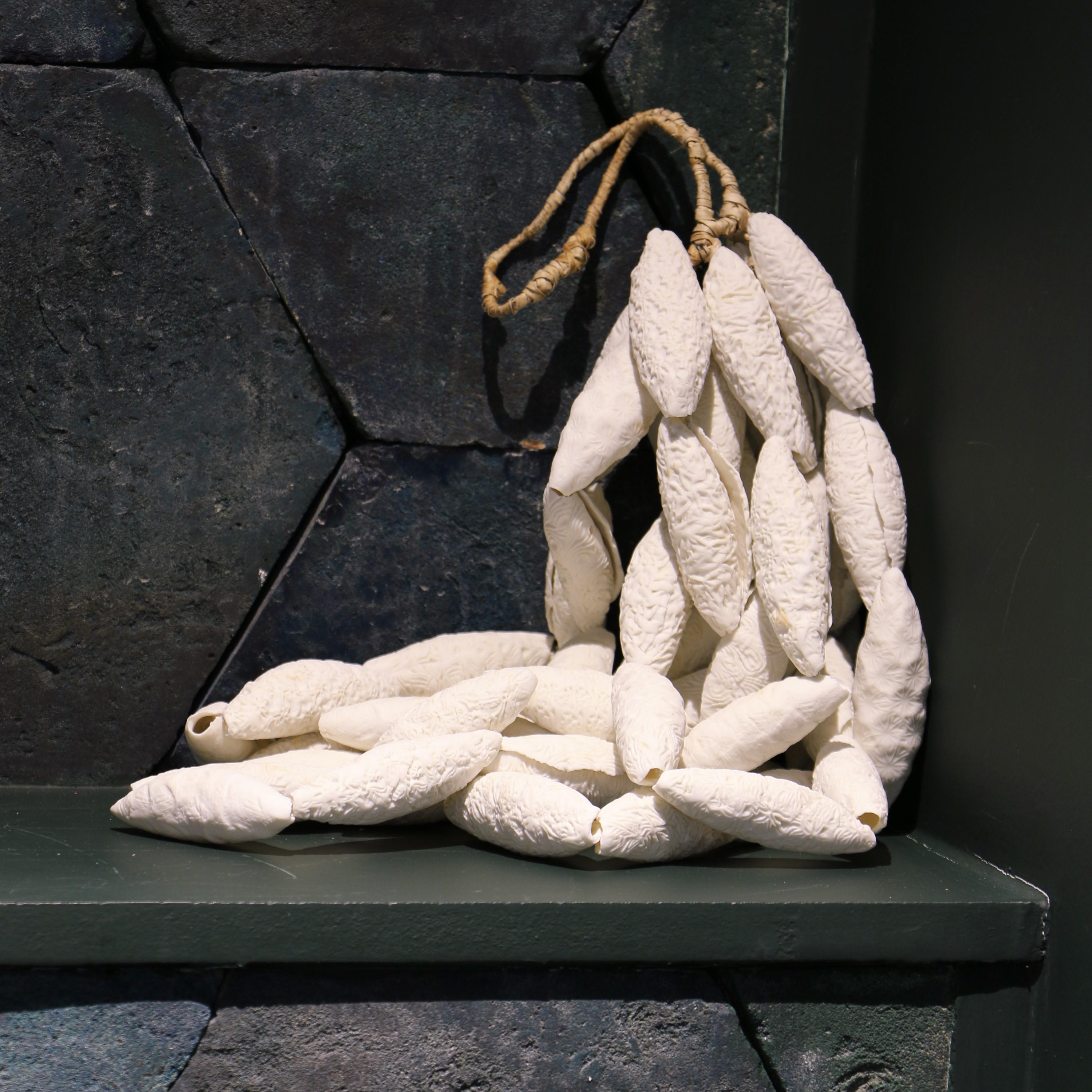 This sculpture entitled «Grappe Sonore» (Sound Cluster), was made by Bénédicte Vallet. It consists of various small ceramic elements, assembled with rope. 

It evokes an organic dimension, mineral and alive. The artist combines her work as a