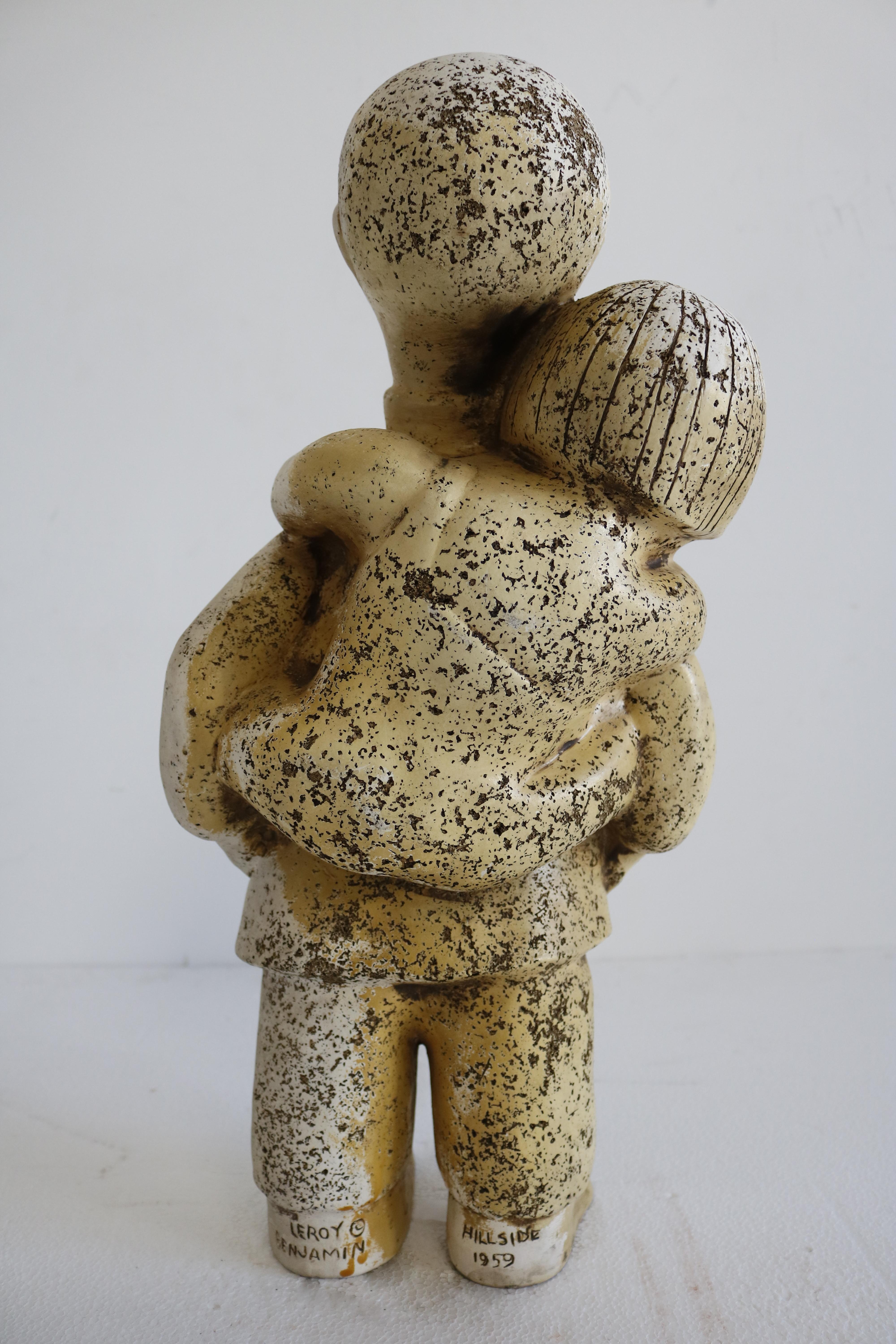 This ceramic sculpture features two people, a father with his daughter on his back in a warm embrace and smiling. Signed on bottom 