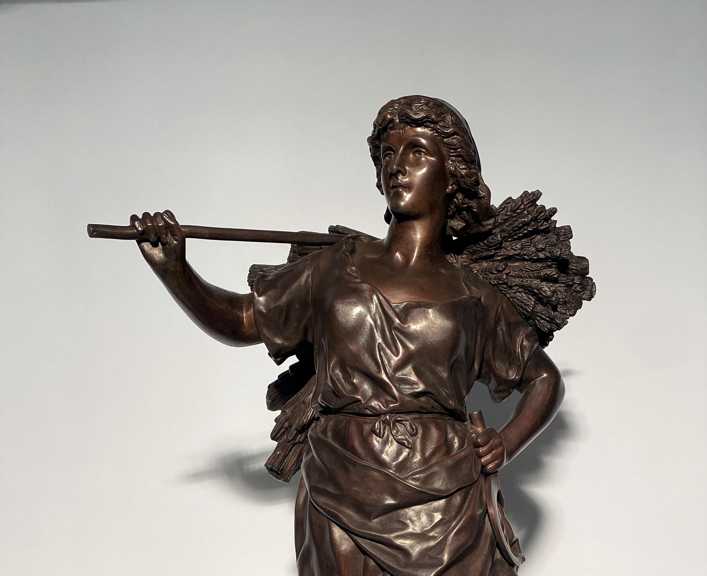 Importante sculpture en bronze à patine brune représentant une jeune femme moissonneuse revenant du travail dans les champs. Notez la belle expression du visage soulignant la satisfaction du travail. Cette œuvre est grande et sculptée sur tous les