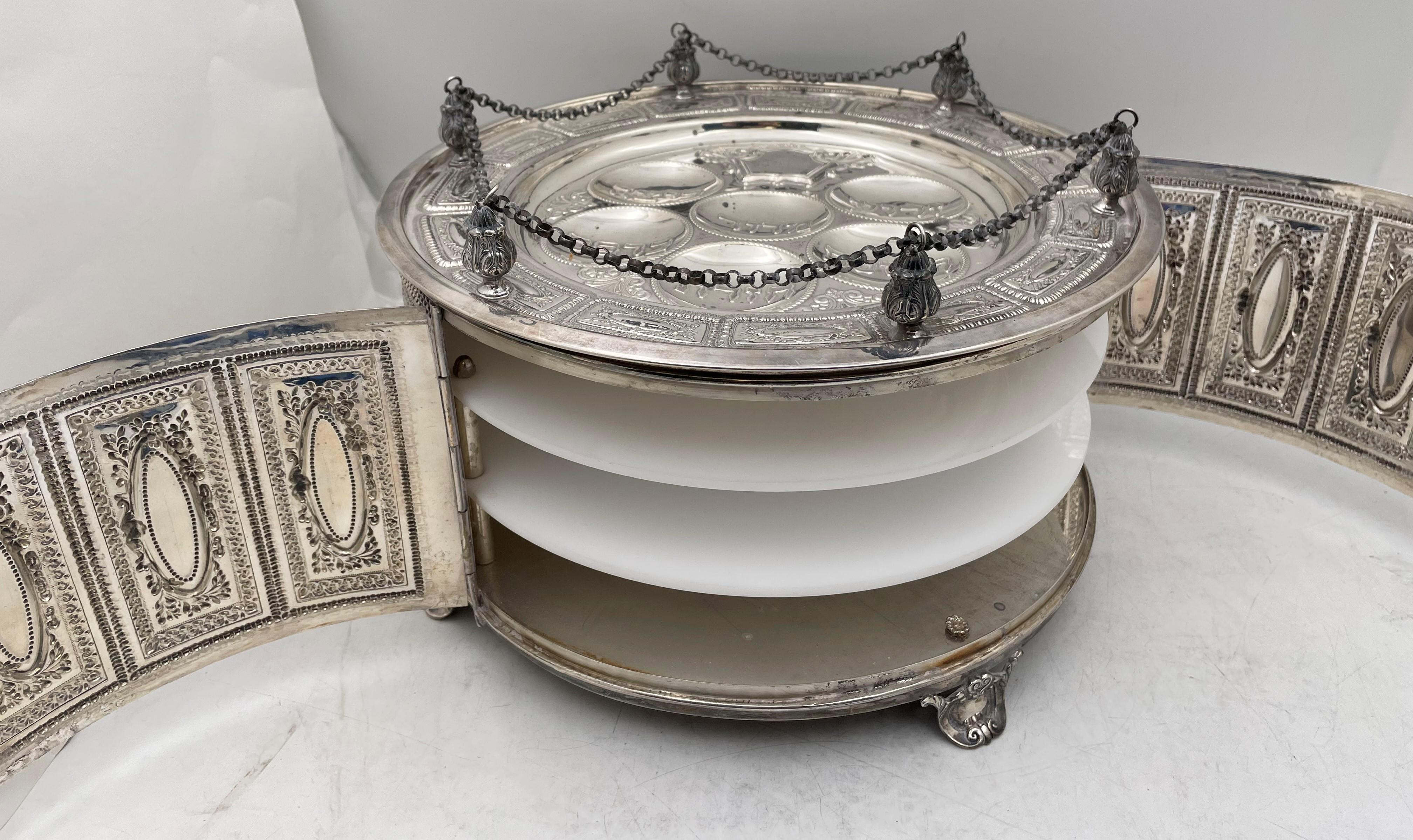 Sterling silver passover seder plate and matza cover with a beautiful, ornate design. There are 3, built-in, lucite trays. 

This exceptional piece, which would be a great addition to a Passover seder table, measures 13 1/2'' in diameter by 8