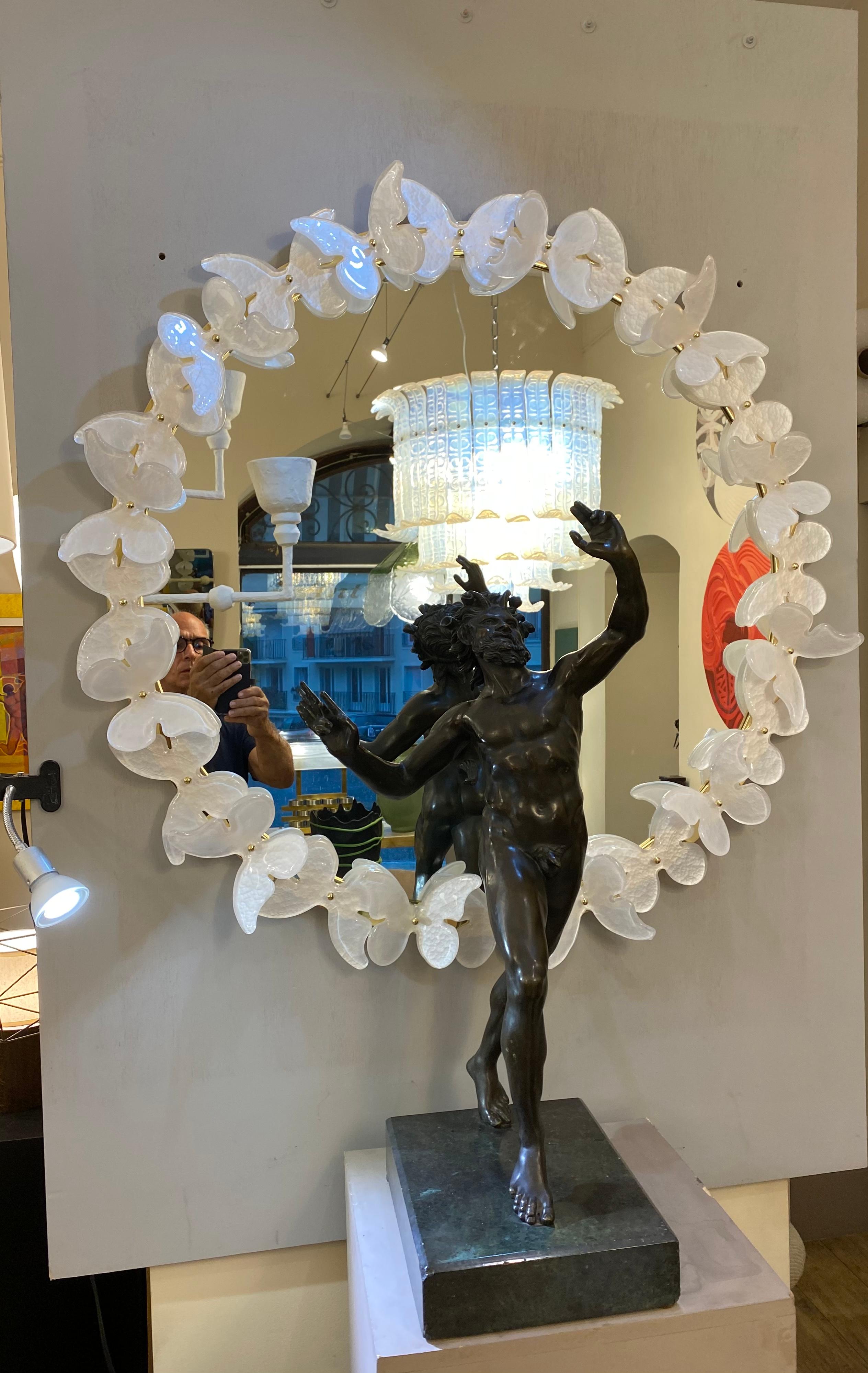 Specchio italiano di Murano, circondato da farfalle in vetro di Murano bianco e grigio. Il supporto è in ottone. Il lavoro dello specchio è molto ben fatto. Può essere posizionato sopra un camino o una console.

Questo specchio circolare è un pezzo