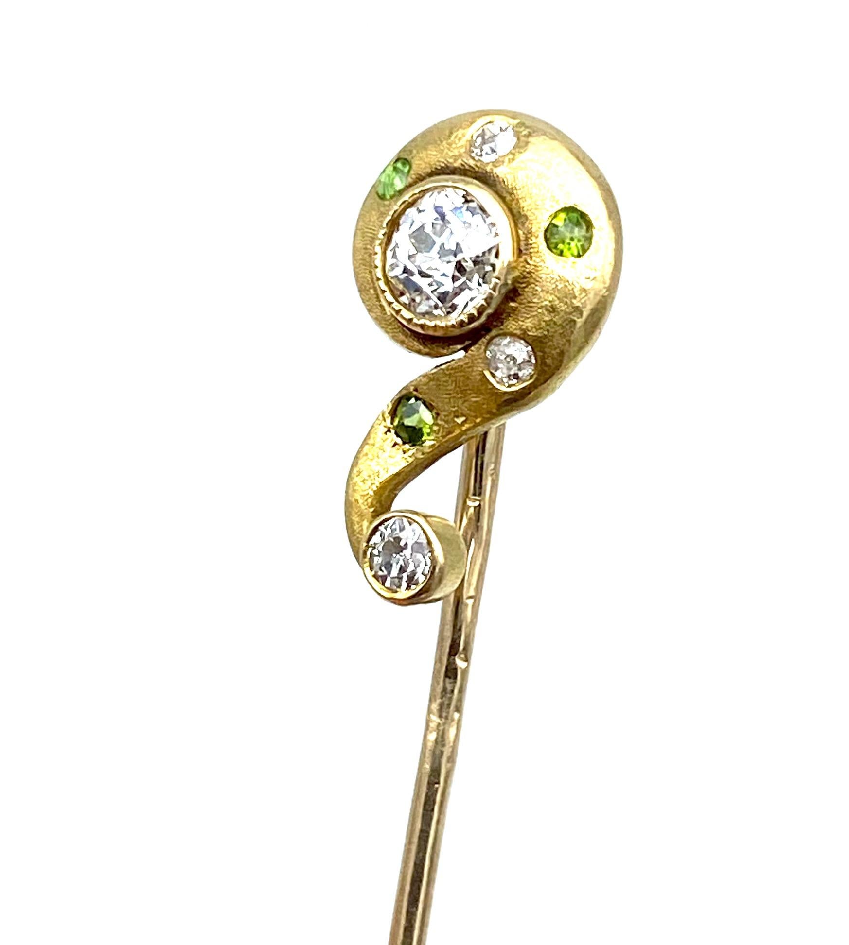 ? Symbol Mine Cut Diamond Pin, Circa 1800's 14 Karat Yellow Gold 

This unique vintage pin has beautiful mine-cut diamonds surrounded by alternating green gemstones & 1 pink accented diamond. 
1- center diamond is 4 mm. The estimated weight is .25