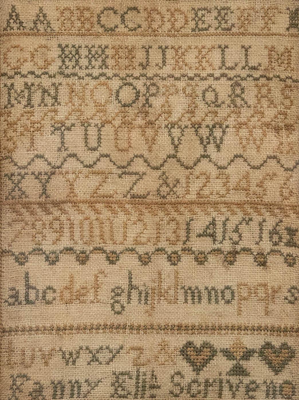 An intricate Victorian sampler by the young Fanny Soriveno, displaying the alphabet in threads of green and yellow.Presented in a beautiful wood veneer frame. On linen. 