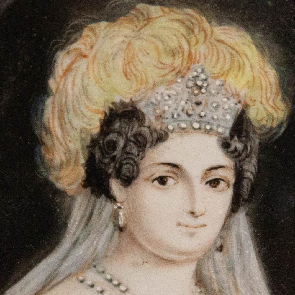 Charmante aquarelle miniature représentant une duchesse dans ses plus beaux atours. Il porte un collier de perles et un diadème orné de plumes. Non signée. Présenté dans un cadre doré avec un cartouche de ruban. Sur un substrat blanc ressemblant à