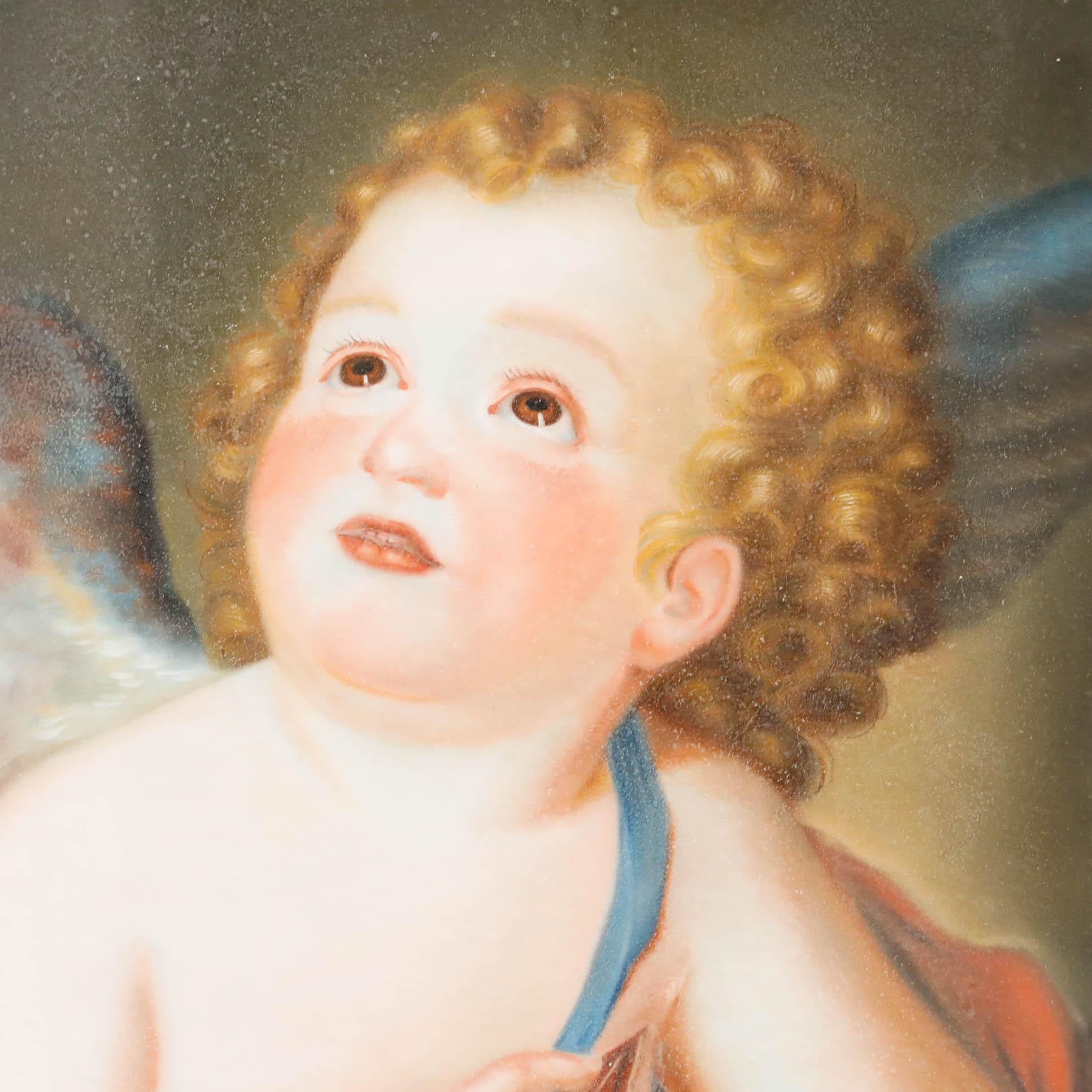 This baroque-style painting depicts a cherubic Cupid with rosy cheeks and golden curls, gazing upward with an expression of wonder and innocence. The composition features warm, luminous tones with the child partially draped in coral and blue fabric,