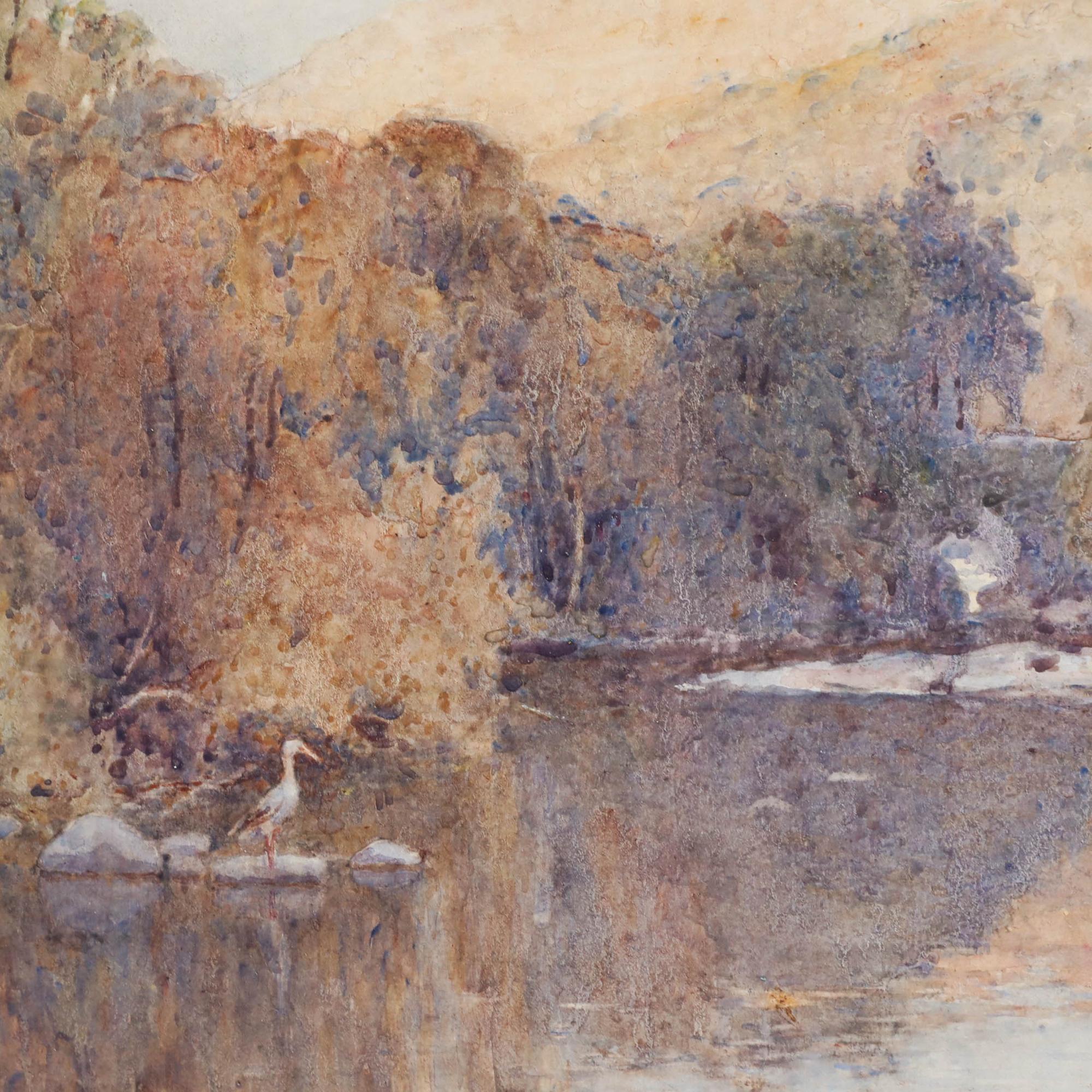Ein Reiher steht auf einem ruhigen See, in dessen spiegelglatter Oberfläche sich das Herbstlaub und die fernen Berge spiegeln. Signiert unten rechts. Gut präsentiert in einem geschwungenen Gold-Effekt-Rahmen mit einer Waschlinie montieren. Eine