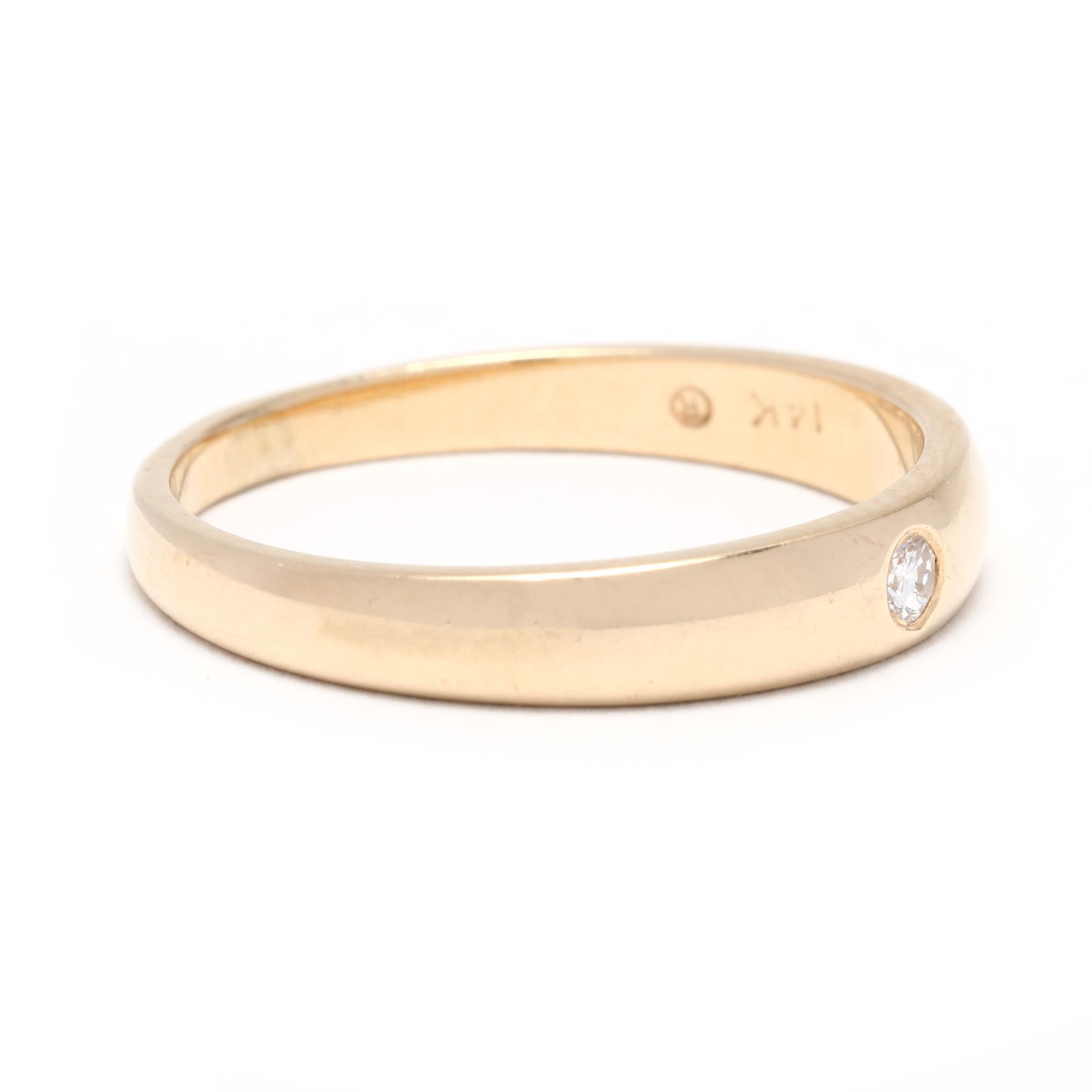 A vintage 14 karat yellow gold thin diamond stackable band ring. This stackable wedding band features a tapered, polished design with a flush set round brilliant cut diamond weighing approximately .03 carat.

Stones:
- diamond, 1 stone
- round