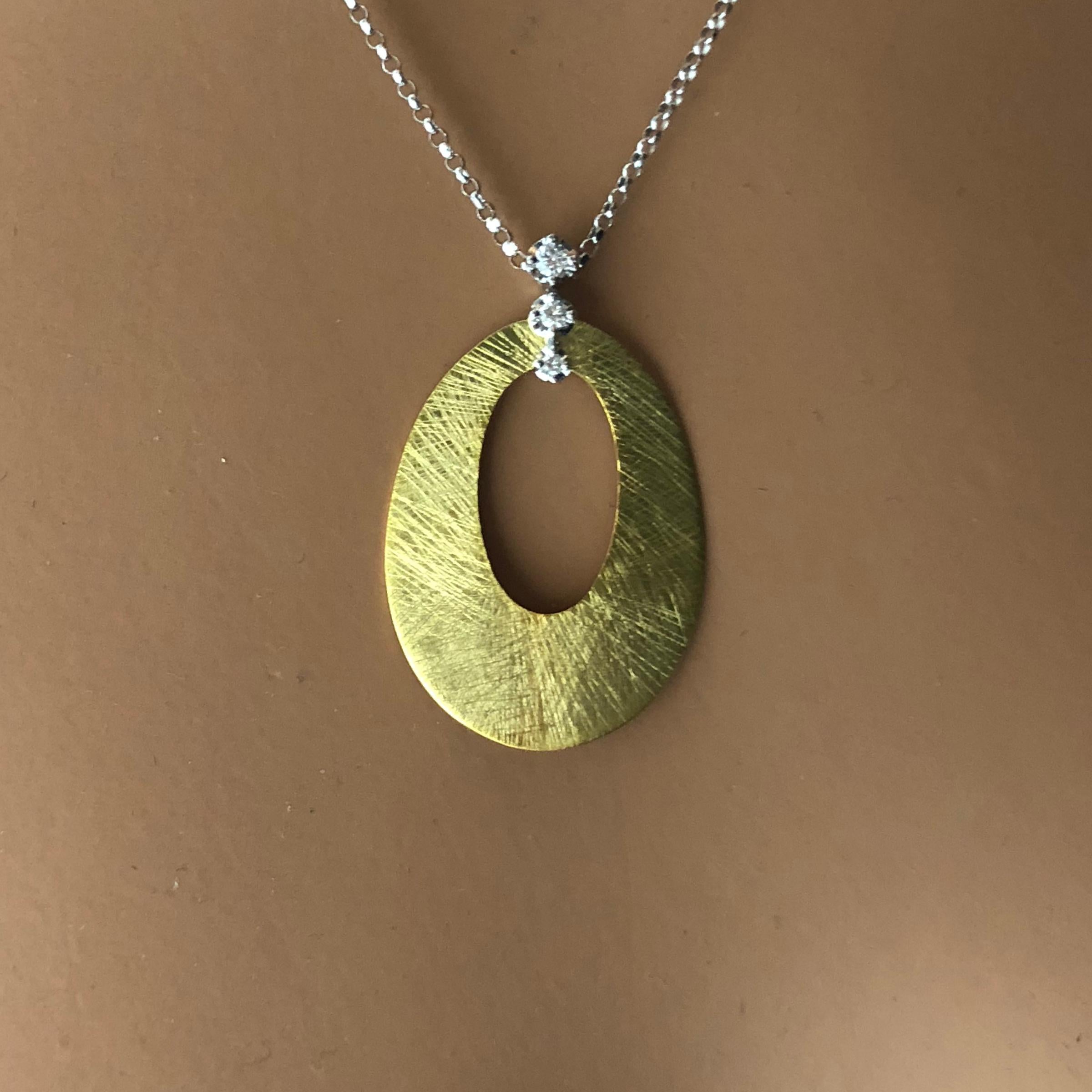 (DiamondTown) This pendant is an oval disc with oval cutout, accented by three round diamonds. Total diamond weight 0.06 carats. A gorgeous accompaniment to any occasion.

Set in 14k Yellow and White Gold.

Many of our items have matching companion