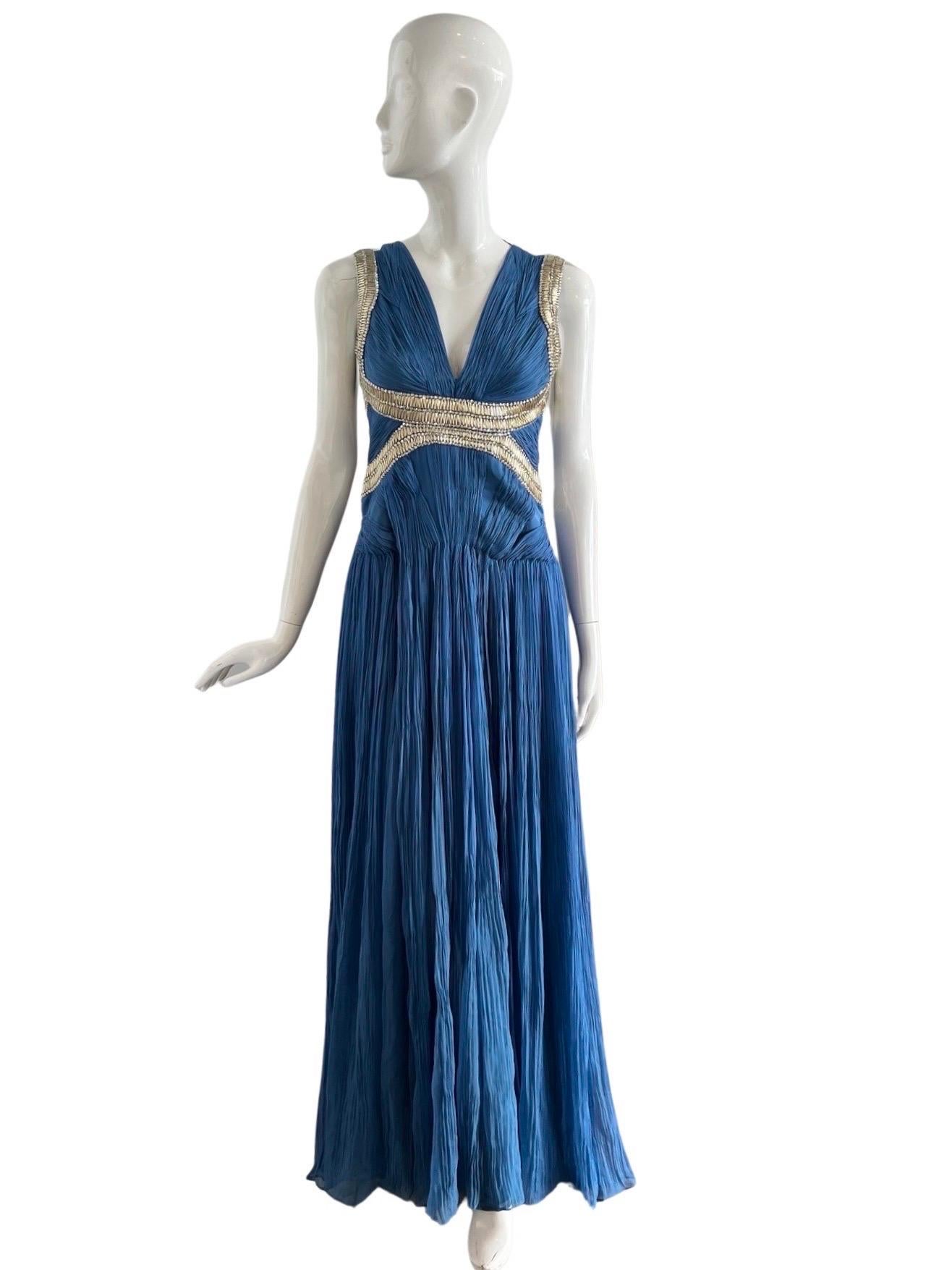 Stunning Roberto Cavalli gown in a blue chiffon silk heavily pleated in a Grecian manner, gathered in sections in the hip area.  The intricate beading is done with clear gem like beads and long tube gold beads interwoven with gold thread.  The back