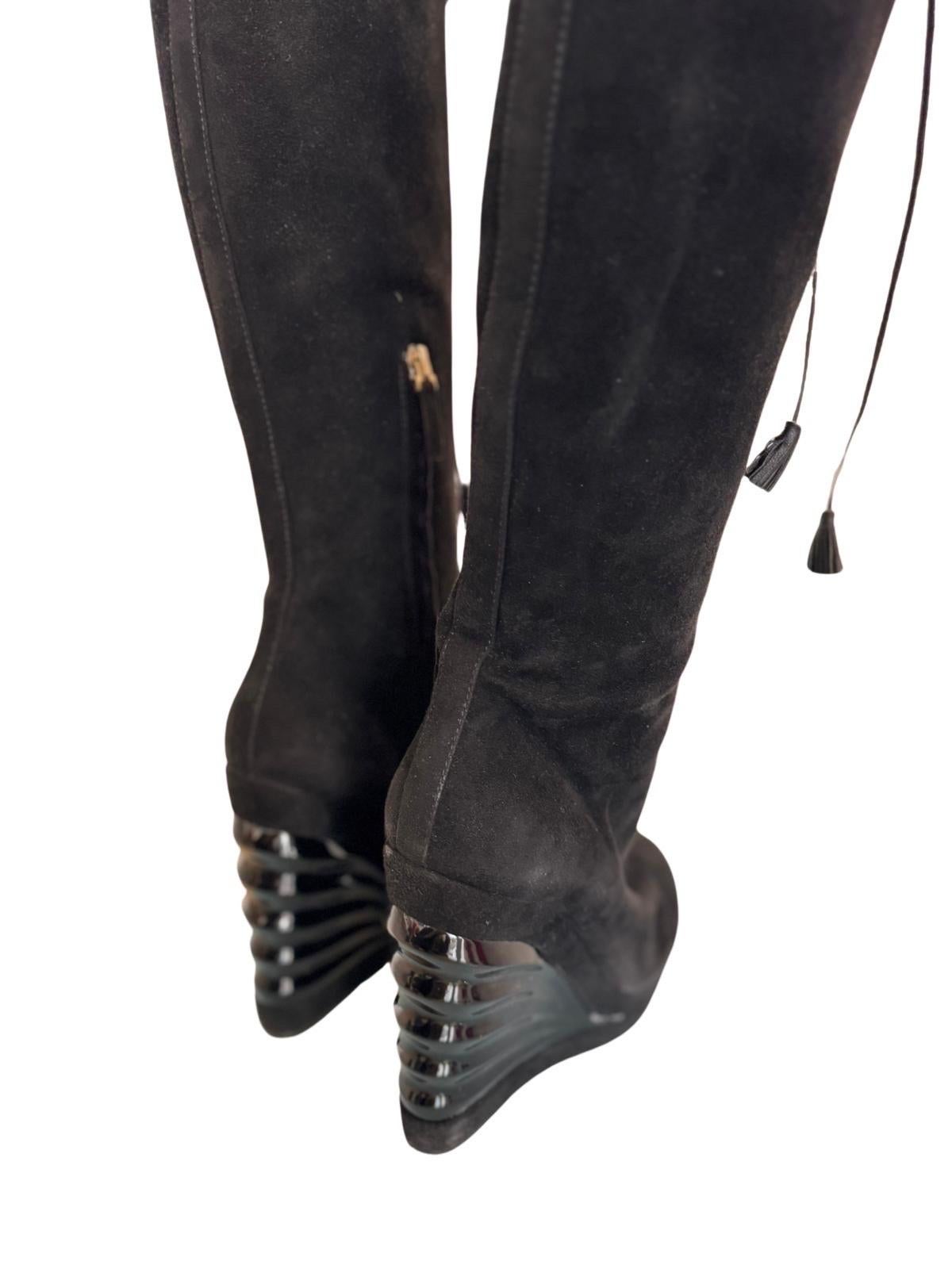Very cool knee high platform boots from early 00's YSL collection.  In black suede with black leather tie up laces, and a zip up the side.  The platform is in a patent that looks like it fans out and upwards in a space age style.  The platform line