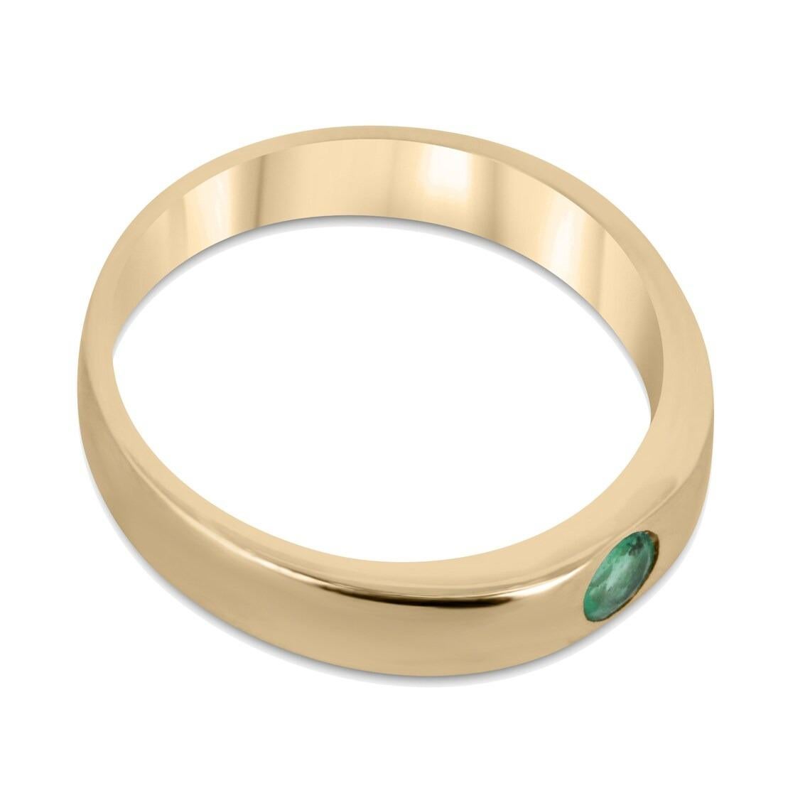 This solitaire emerald band ring features a stunning round-cut emerald stone set in the center of a 3.9mm band crafted from high-quality 14k gold. The emerald boasts a medium green color with good luster and is securely held in place by a bezel