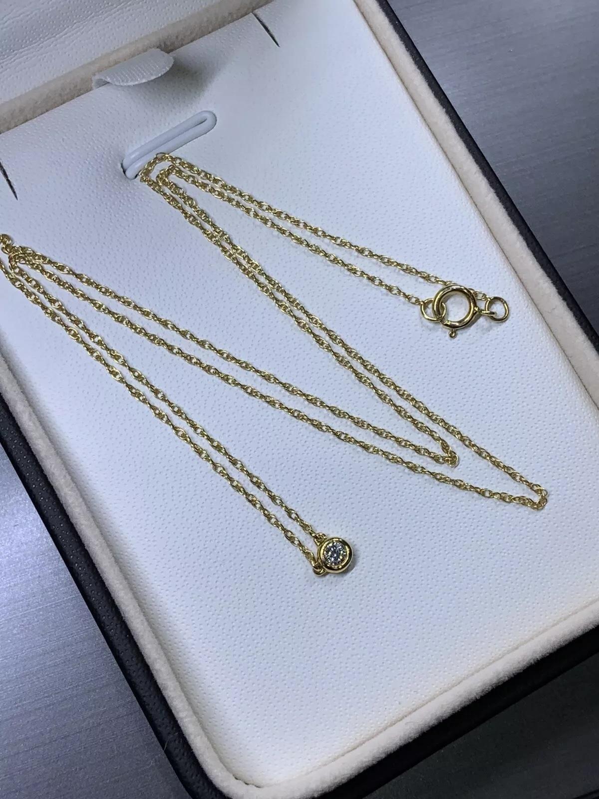 Ajoutez une touche d'élégance à votre tenue avec ce magnifique collier à pendentif solitaire. Le pendentif est réalisé en or jaune 18ct et comporte un diamant rond d'un poids total de 0,10 carat. Le collier mesure 18 pouces de long et possède un