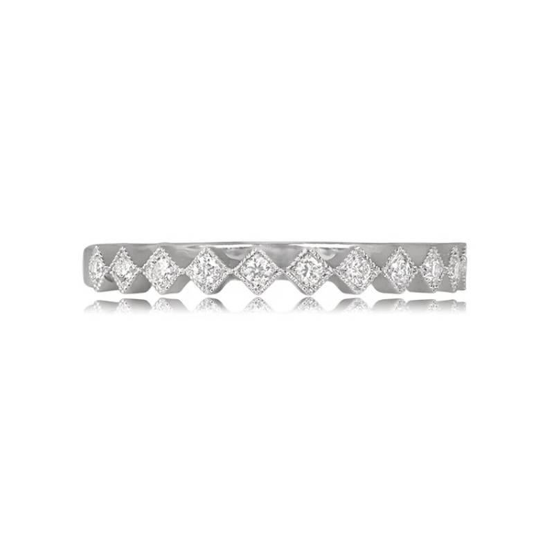 A meticulously handcrafted half-eternity band in elegant 14k white gold, adorned with 0.10 carats of round brilliant cut diamonds. Each diamond is securely set in prongs and encircled by diamond-shaped bezels, enhancing the band's allure. With a