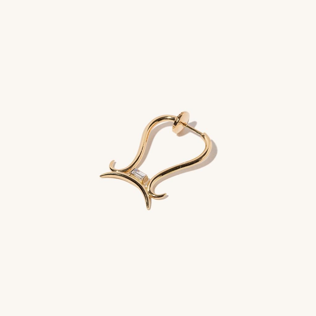 Zodiac inspired items are special items that have long been said to be auspicious. MILAMORE's zodiac motif earrings take form in 18 karat yellow gold accented with a single, sparkling, baguette-cut diamond and finished in an abstract shape that