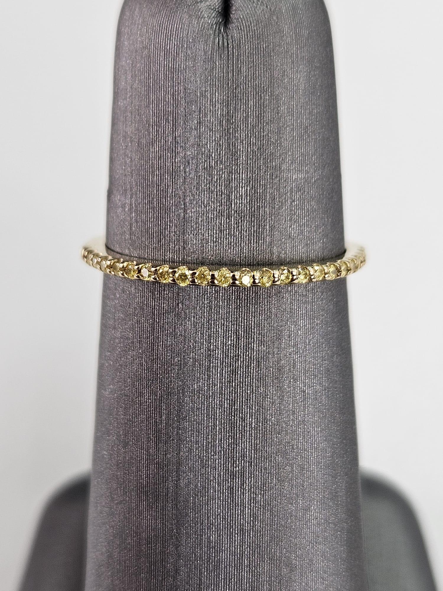 Voici une luxueuse et captivante bague à anneau en diamant jaune fantaisie de 0,11 carat, exquisément réalisée en or jaune radieux, conçue pour enchanter par son extraordinaire brillance. Cette magnifique bague présente un anneau orné d'une rangée