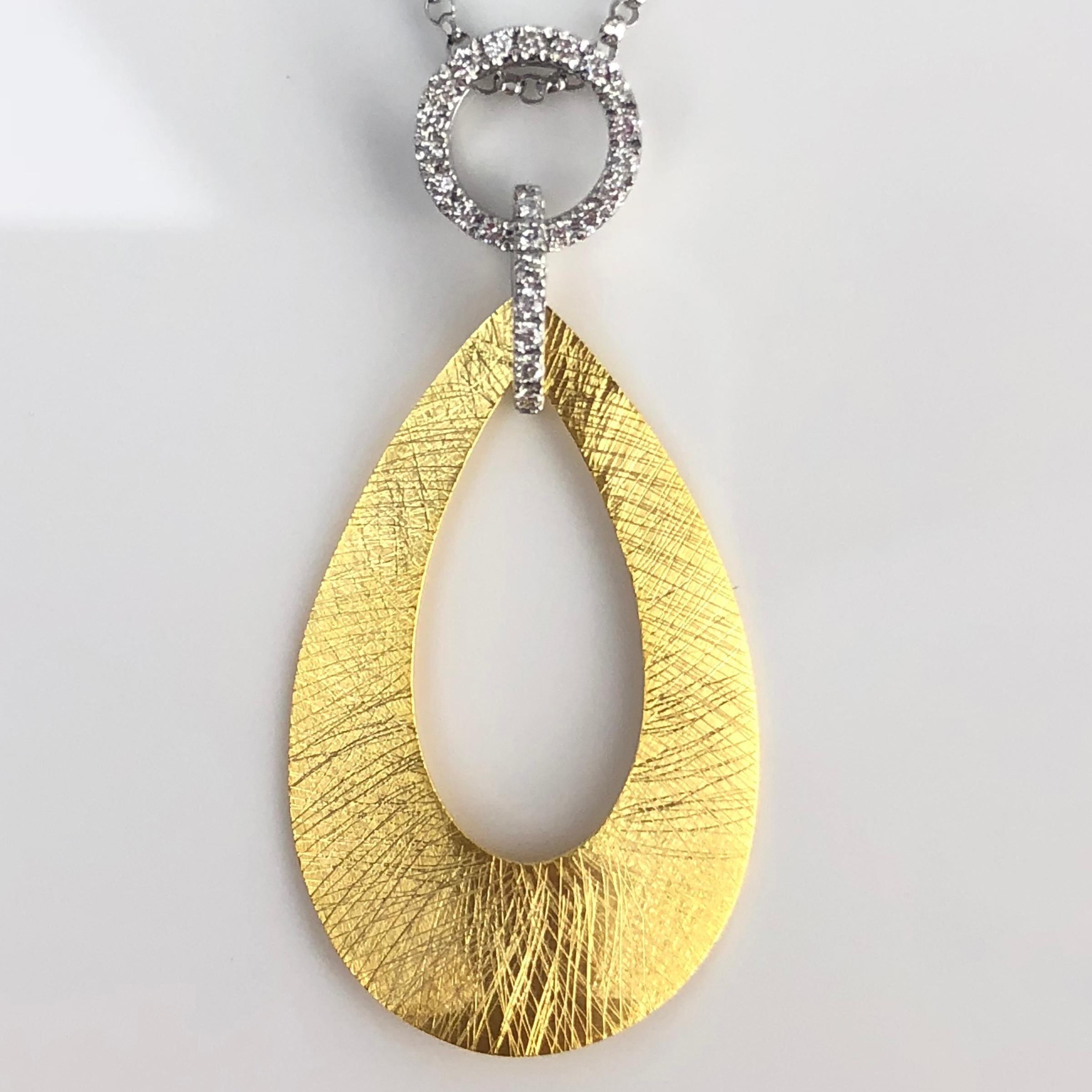 This pendant is a teardrop disc, with a teardrop cutout, with 0.12 carats round diamonds decorating the bail. Set in 14k Yellow and White Gold.

Many of our items have matching companion pieces. Please inquire.

An insurance appraisal certificate