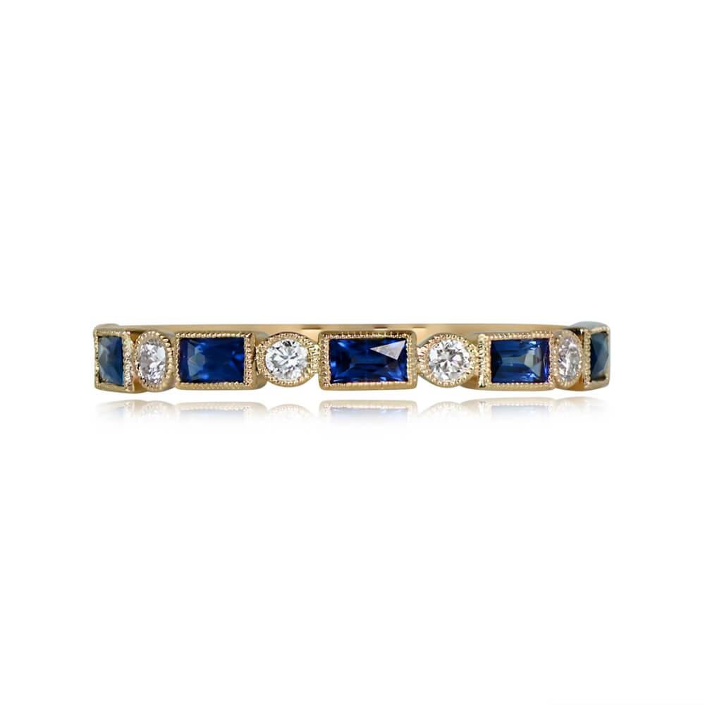 An exquisite half-eternity wedding band crafted in 18k yellow gold. The alternating design showcases elongated French cut sapphires, totaling 0.51 carats, and round brilliant cut diamonds weighing 0.12 carats. Each gem is bezel-set, creating a