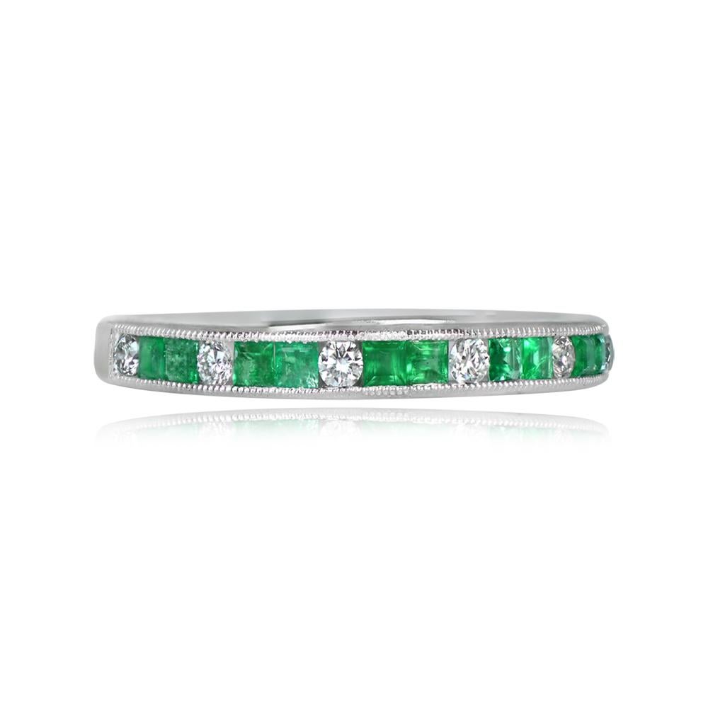 This platinum half-eternity band showcases a captivating design with alternating round brilliant-cut diamonds and 
calibre natural green emeralds. The stones are meticulously channel-set, accentuated by delicate milgrain detailing.

Diamond Weight: