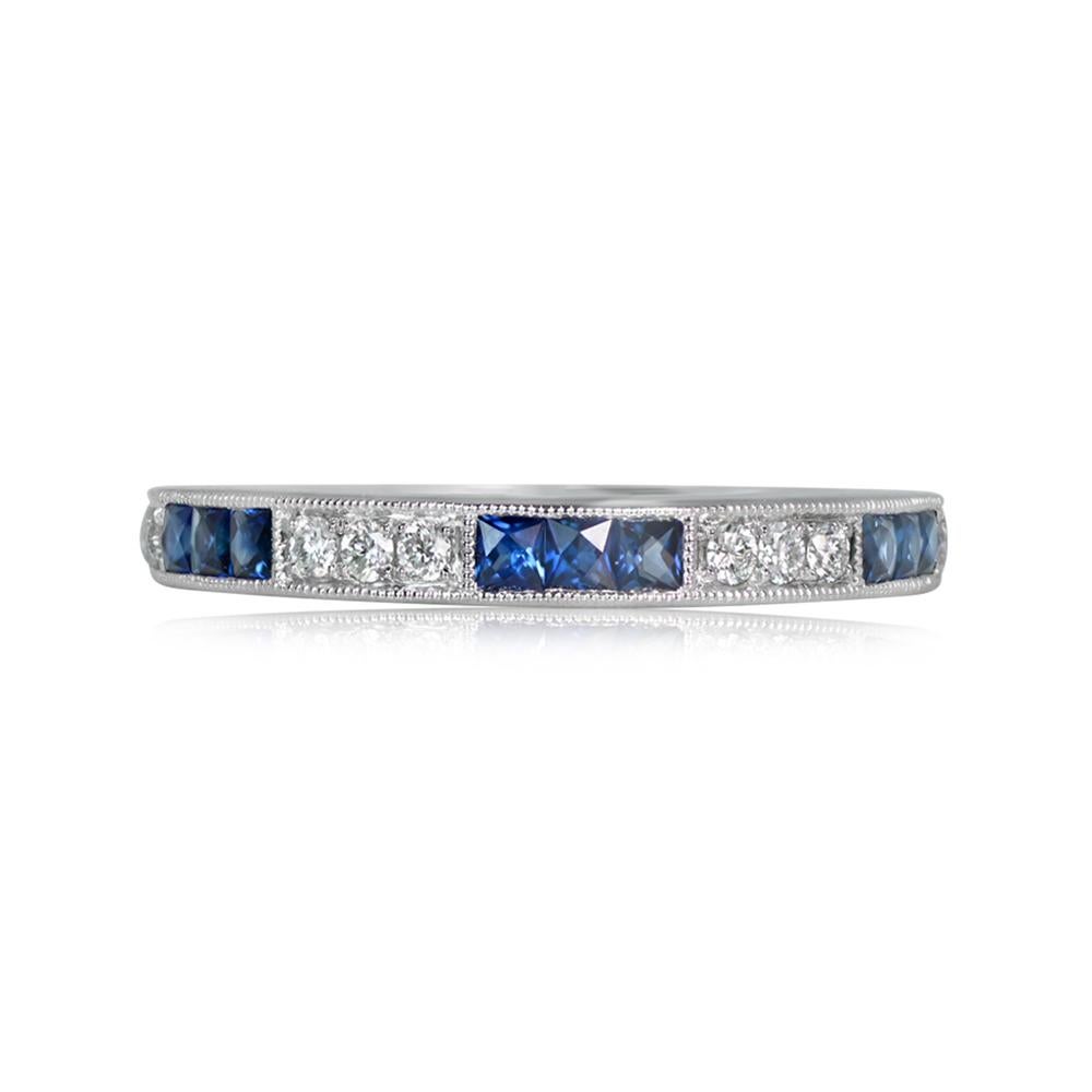 A stunning half-eternity band crafted in platinum, featuring alternating micro-pave set round brilliant cut diamonds and channel-set French-cut natural blue sapphires. The band is 2.60mm wide, with a total approximate diamond weight of 0.14 carats