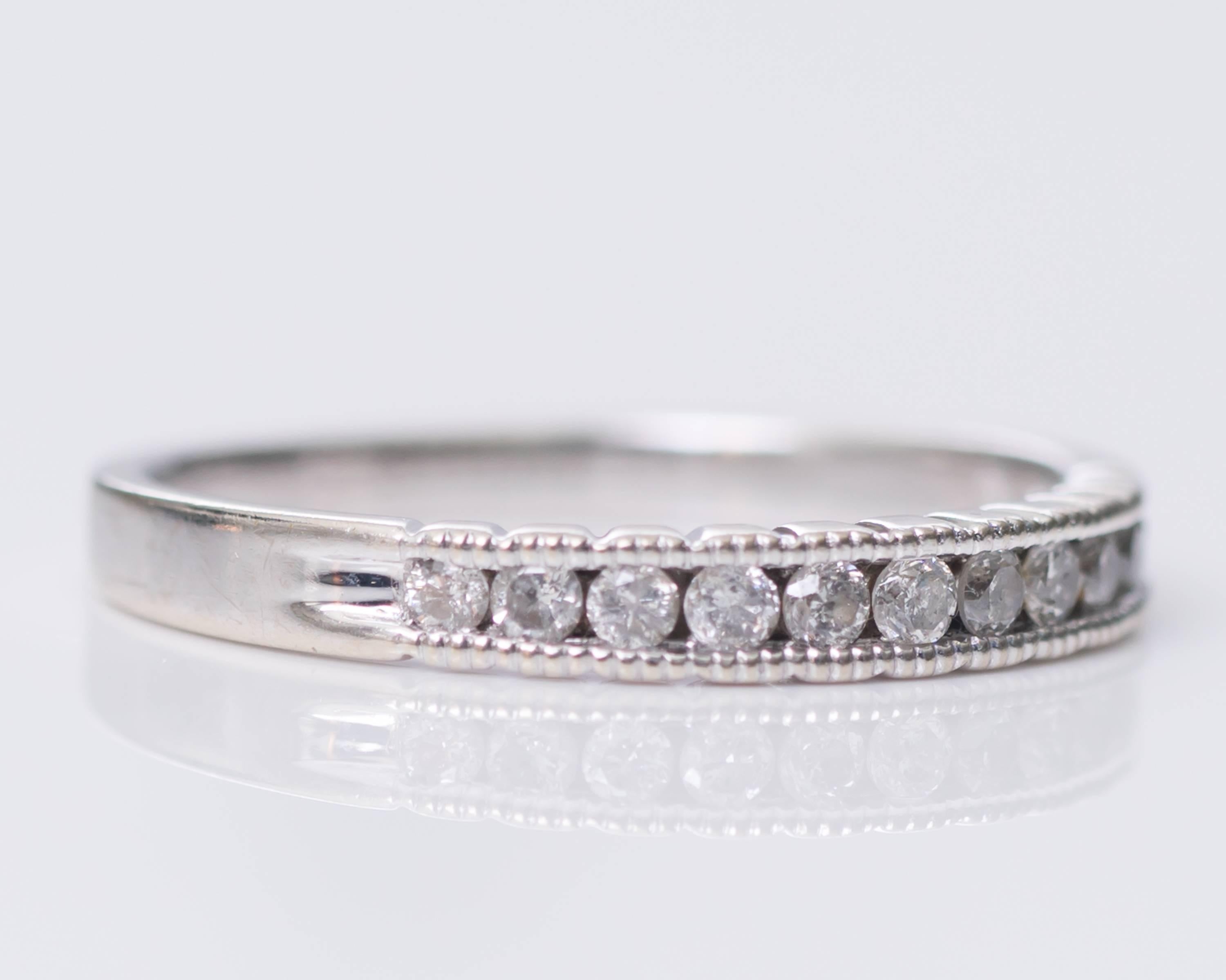 Diamond Eternity Band - 14 Karat White Gold, .15 carat total weight Round Brilliant Diamonds

Features a row of Round Brilliant Diamonds set along front half of the ring. A fine milgrain design embellishes the upper and lower edges of the shank