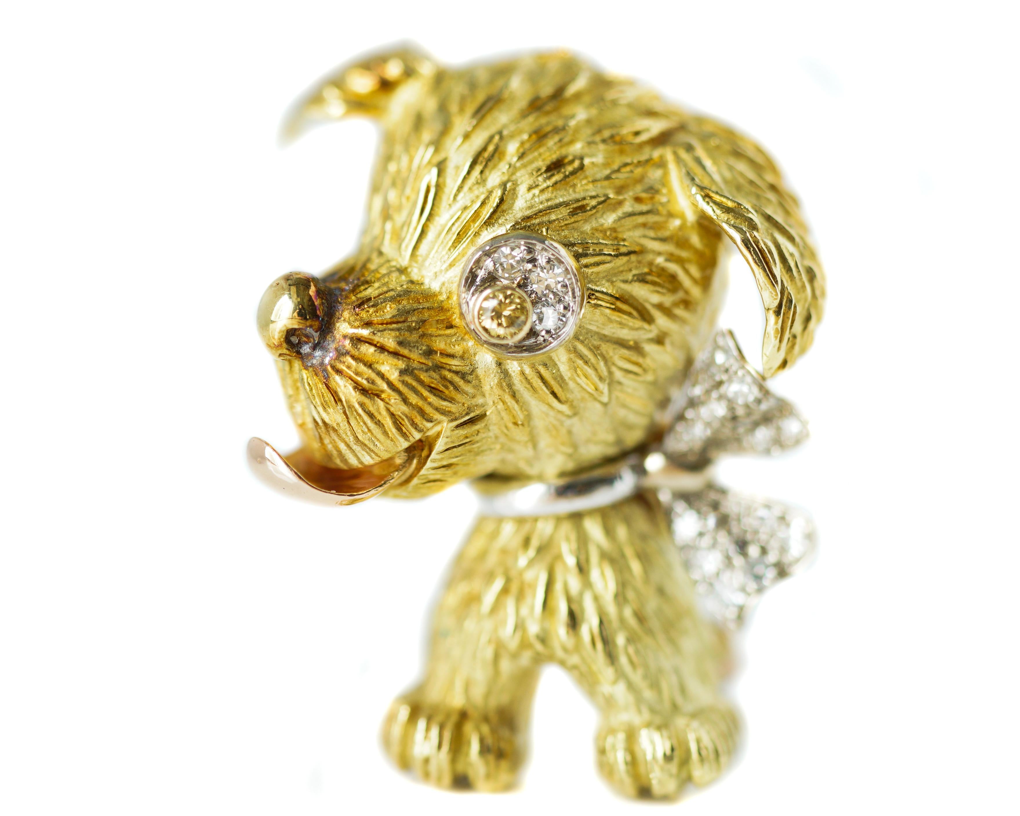 Features:
Large Headed Puppy Attentively Seated with Perky Ears, Round Nose, Sparkling Eye and Outstretched Tongue. 
Puppy is wearing a Diamond Bow Collar, 0.15 carat total weight 
Heavily fur-textured 18 karat Yellow Gold Head and Body
Smooth