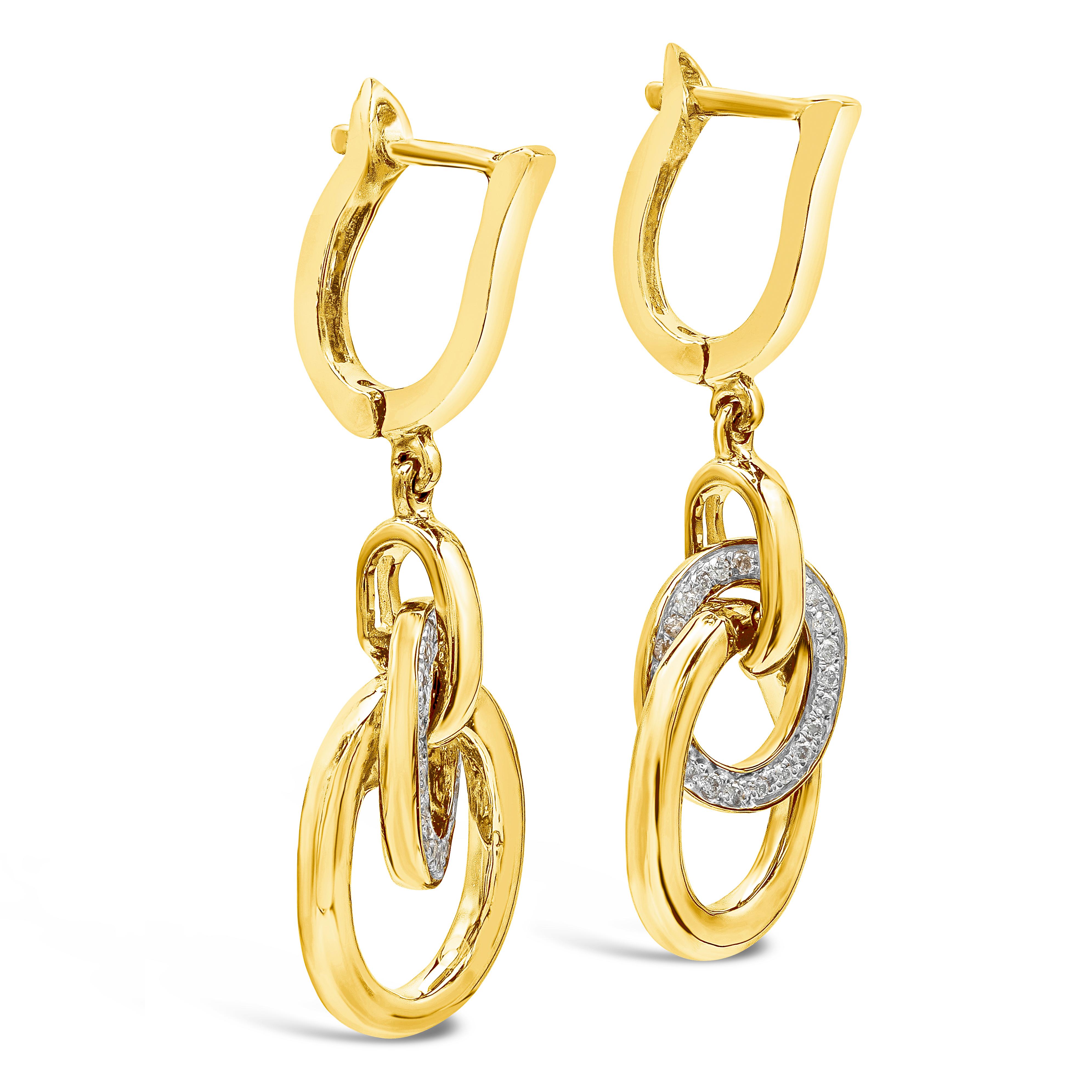 A versatile pair of dangle earrings showcasing connected open-work rings, one of which is accented with round diamonds, made in 14k yellow gold. Attached to a small hoop. Diamonds weigh 0.15 carats total.