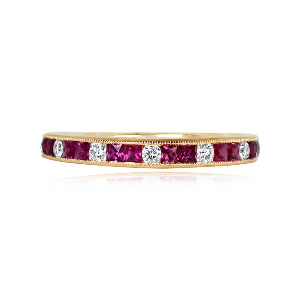 An 18k yellow gold half-eternity band featuring an alternating pattern of channel-set round brilliant cut diamonds and French-cut rubies. The band, adorned with fine milgrain, has a width of 2.5mm. The total diamond weight is 0.15 carats, and the