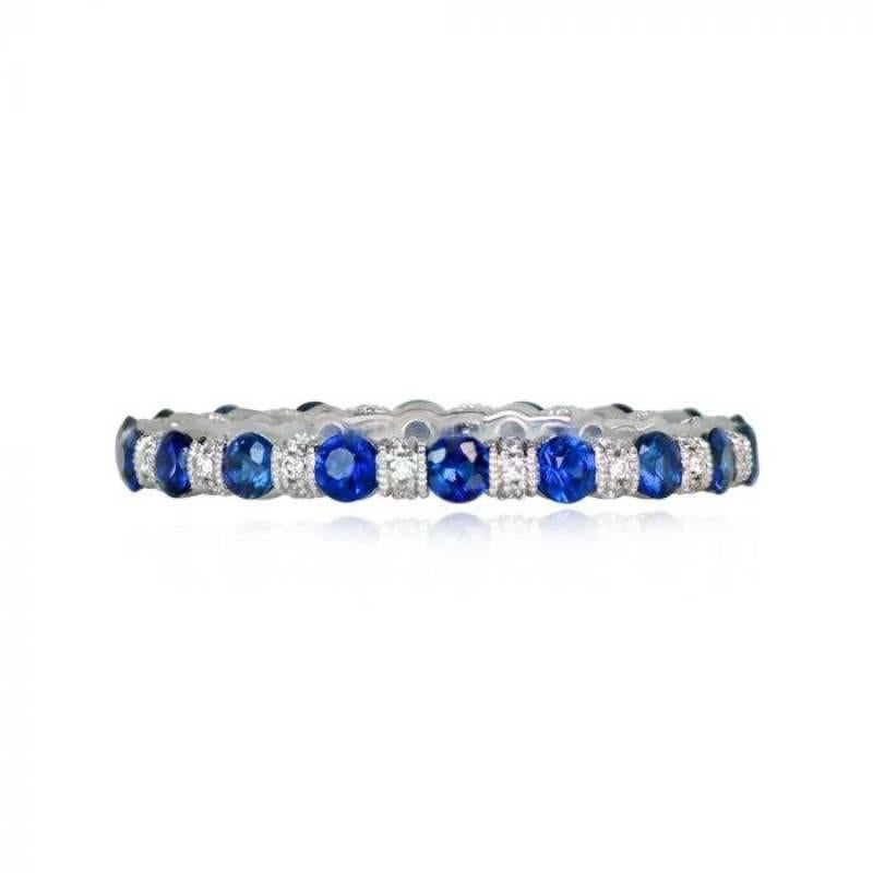A stunning eternity band showcasing 0.15 carats of round brilliant cut diamonds and 0.88 carats of natural round-cut sapphires. The diamonds are pave-set, while the sapphires are set with shared prongs. Handcrafted in platinum, the band has a width
