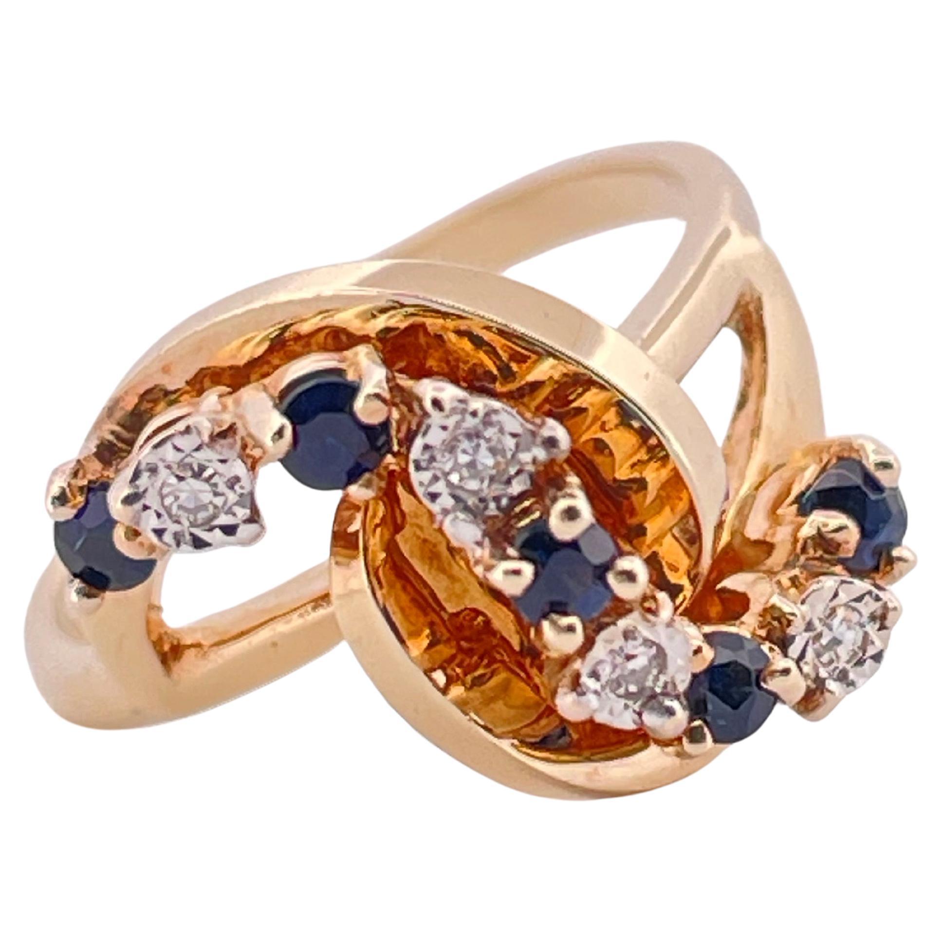 Dieser elegante Ring aus 14-karätigem Gelbgold besticht durch sein raffiniertes Wirbeldesign, das klassische Edelsteine mit einem modernen Touch verbindet. Auf dem geschwungenen Bypass sind ca. 0,15 Karat tiefblaue Saphire eingefasst, die einen