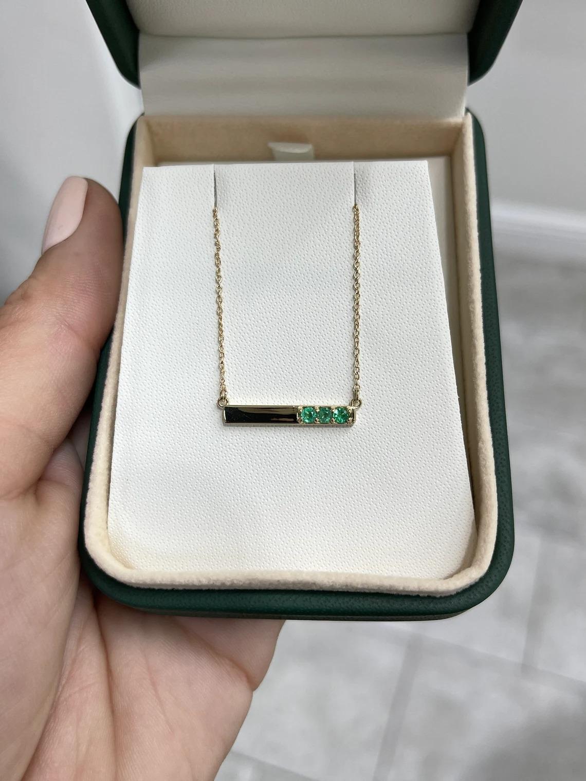 A gorgeous emerald necklace, that features three dainty natural emeralds that are from the mines of Zambia. These petite stones showcase a beautiful emerald green color, clarity, and luster. Carefully crafted and set in 14K gold, attached to a