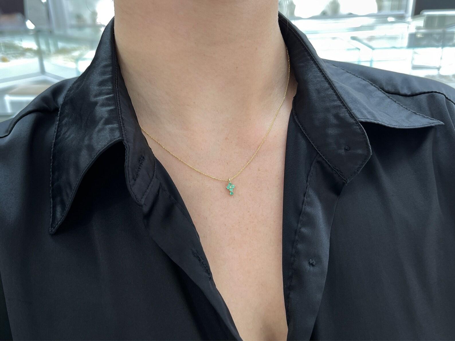 A token of faith, a symbolic emerald cross. This petite necklace features numerous bluish-green emeralds, prong-set in a simple yet beautiful gold prong setting. Crafted in 14K gold, and ideal for everyday wear and stacking.

*Chain sold