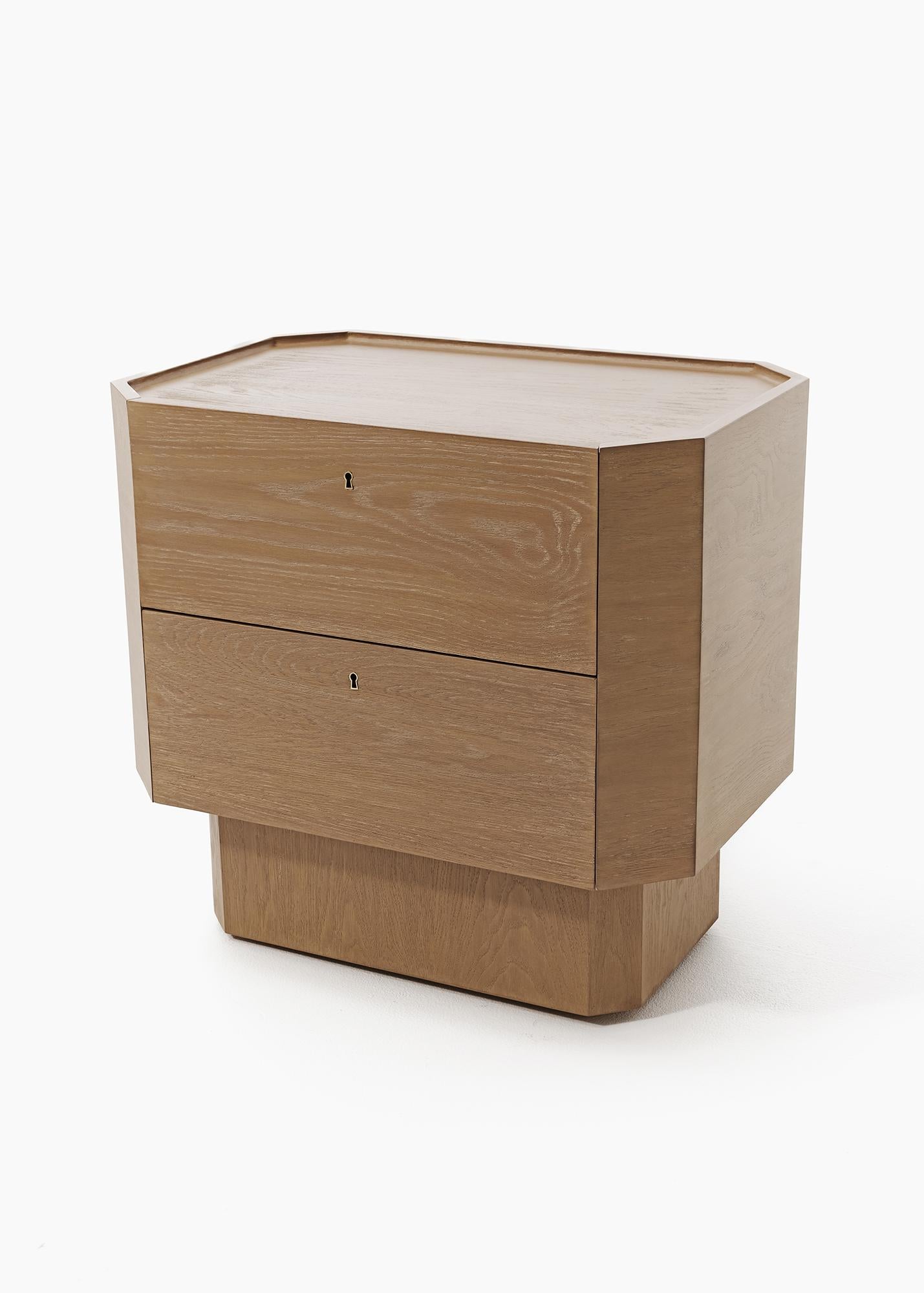 UN GARDIEN DES SECRETS

Une table de chevet à deux tiroirs est faussement simple, équilibrant soigneusement l'art de la forme et de la fonction. Les détails, notamment un plateau de table à huit côtés, évoquent la géométrie sacrée, tandis que le