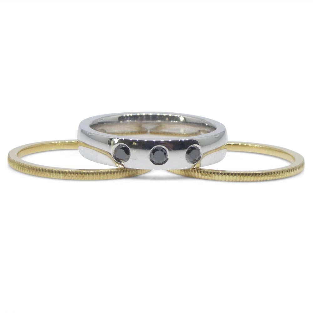 This refined set features three delicate stacker rings, each adorned with a 0.06ct black diamond, totaling 0.18ct. Crafted from high-quality 18K white and yellow gold, these rings are designed to be worn together or separately, offering versatile