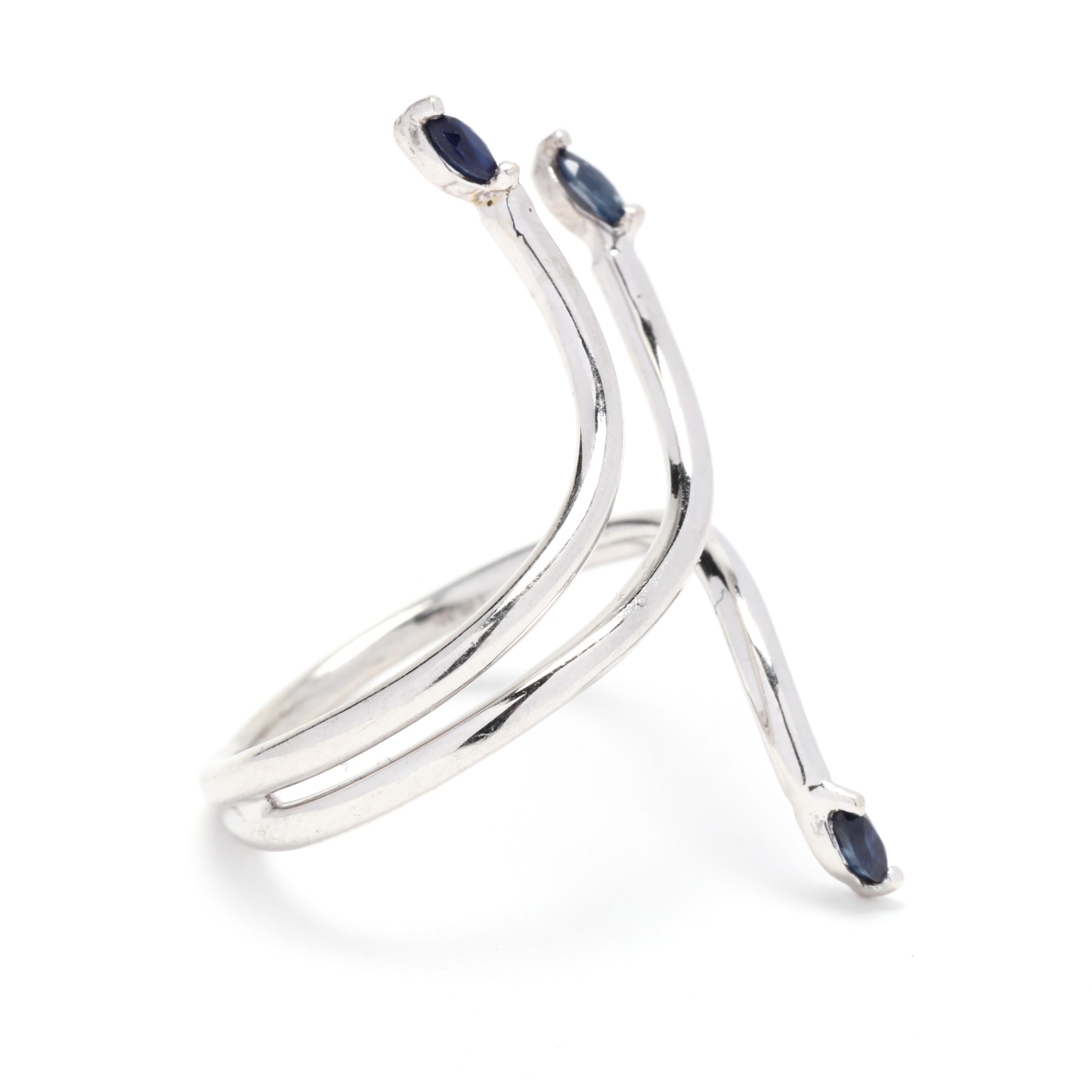 An 18 karat white gold Italian sapphire bypass wrap ring. This long sapphire ring features a wrap around design with thin white gold wire set with marquise cut sapphires at the ends weighing approximately .18 total carats.

Stones:
- sapphire, 3