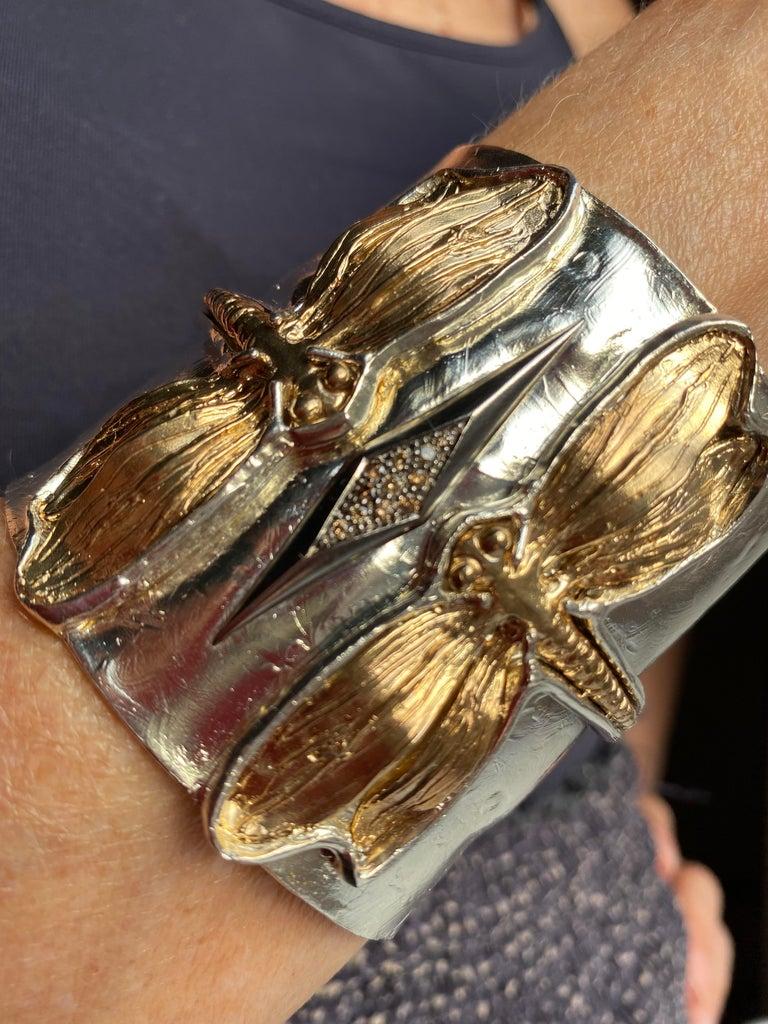 Handcrafted 0.18 Karat Diamonds made in 24 Karat Gold plated Silver Bronze Dragonfly Cuff Bracelet is a  bracelet for the animal lovers. 
On the silver sterling bracelet two gold plated bronzed dragonfly meet and by their encounter a regal diamonds