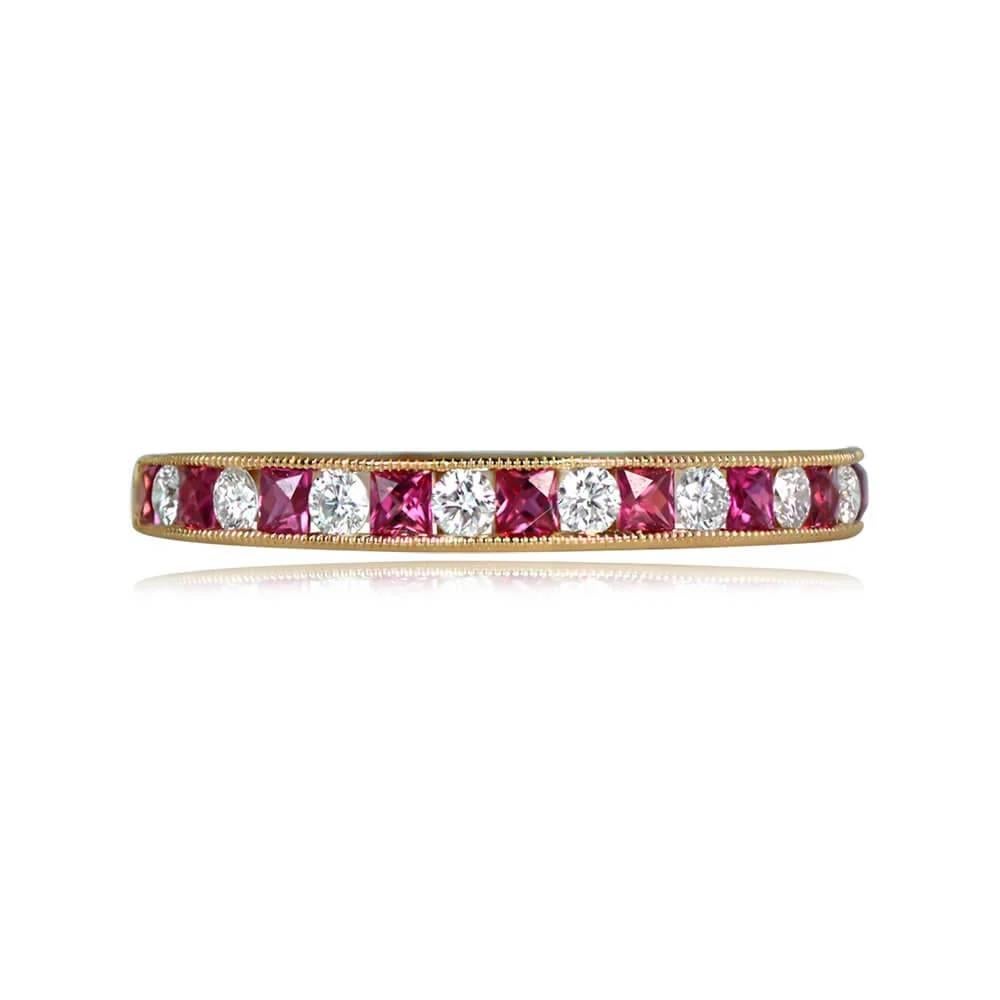 An 18k yellow gold half-eternity band featuring an alternating pattern of channel-set diamonds and French-cut rubies. The band, adorned with fine milgrain, has a width of 2.4mm. The total diamond weight is 0.19 carats, and the total ruby weight is