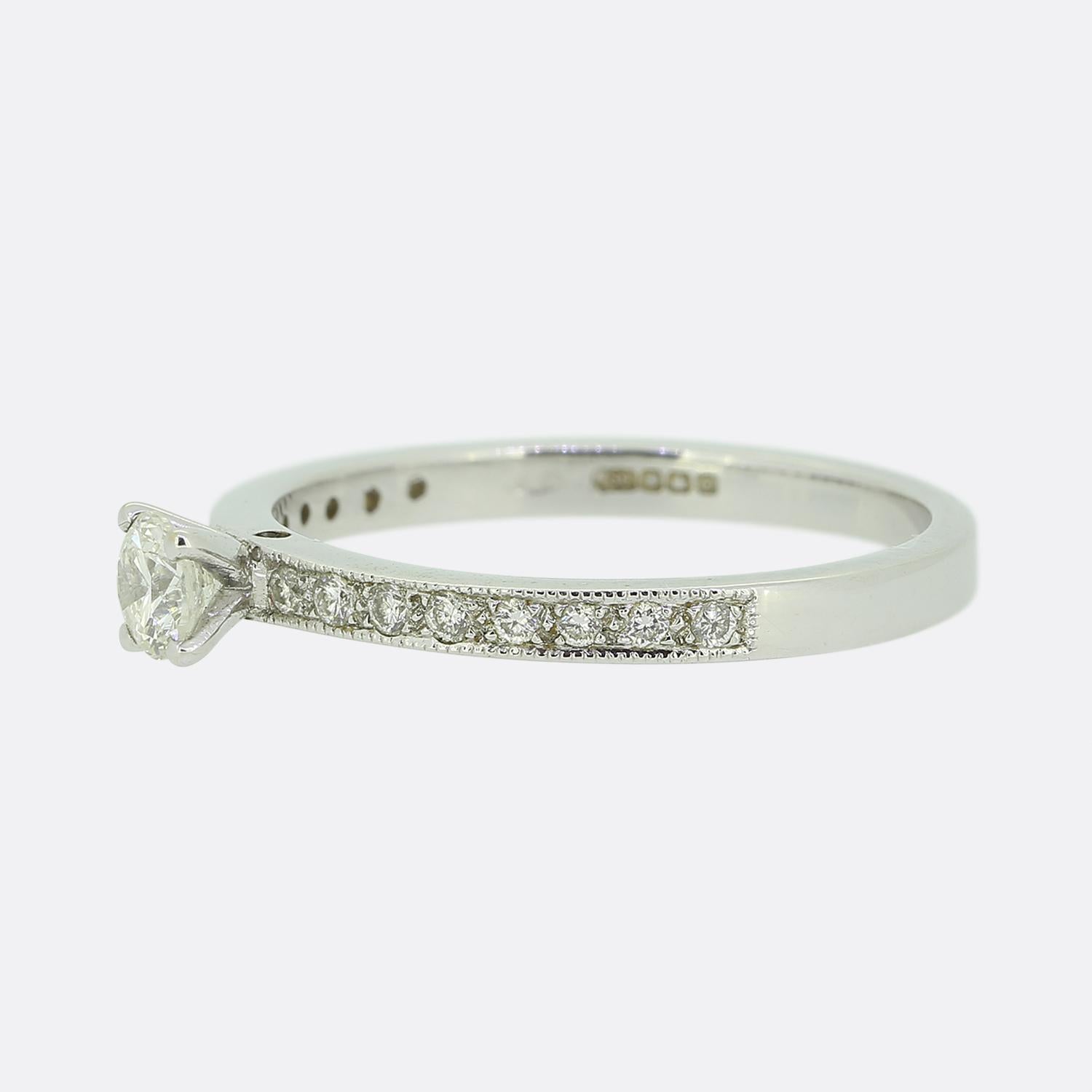Dies ist ein Solitär-Diamantring aus 18 Karat Weißgold. Der Mittelstein ist ein runder Diamant im Brillantschliff von 0,20 Karat und jede Schulter ist mit 8 kleineren Diamanten besetzt.

Zustand: Gebraucht (Sehr gut)
Gewicht: 2.7 Gramm
Größe: