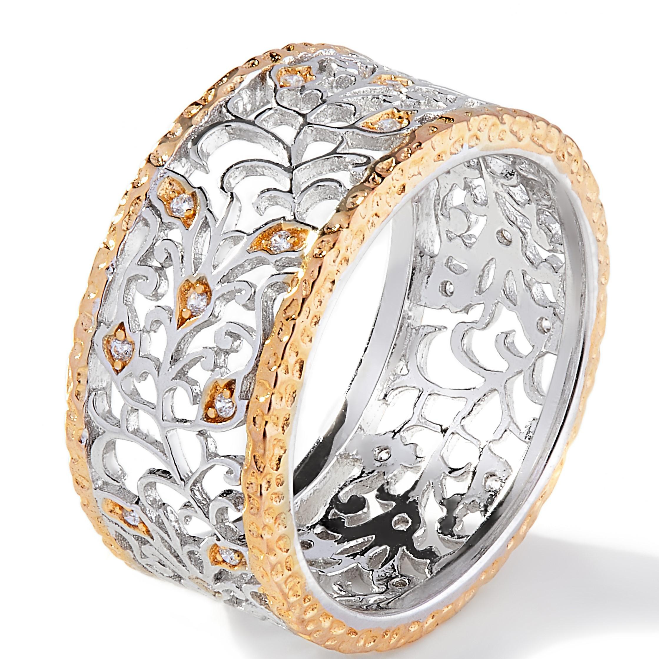 The outer bands of 14kt yellow gold hammered silver creates a stunning contrast of colour with the exquisite floral inspired filigree detail within.

This broad open worked ring beautifully claw set with 0.20ct cubic zirconia is encapsulated with in