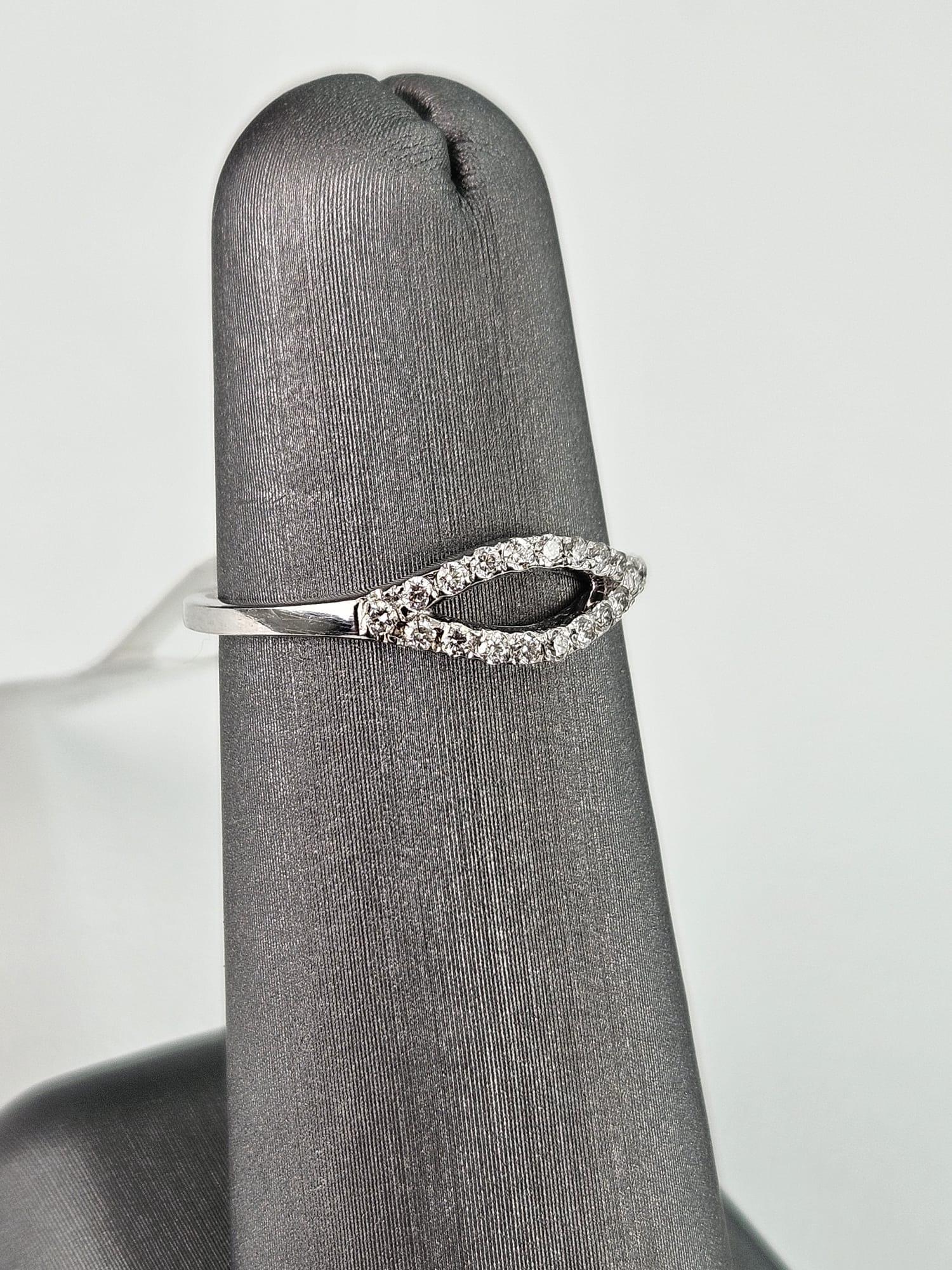 Introducing a uniquely elegant 0.20 carat White Diamond oval band ring, gracefully designed with an open oval shape in the middle, crafted in luminous white gold. This exquisite ring features shimmering White Diamonds, totaling 0.20 carats,