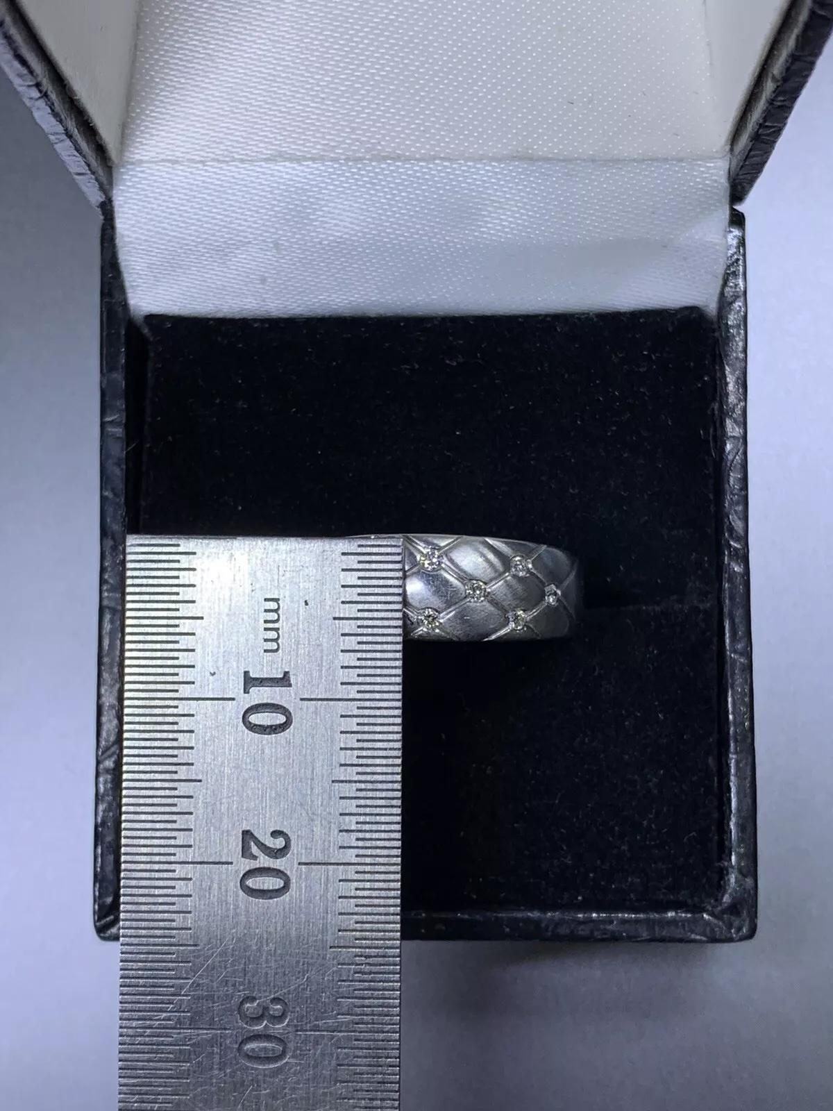 Dieses atemberaubende Verlobungsband besteht aus insgesamt 10 natürlichen Diamanten im Rundschliff mit einem Gesamtkaratgewicht von 0,20 ct. Die Diamanten sind bündig in ein 18-karätiges Weißgoldband mit mattem Finish eingefasst. Der Ring hat die