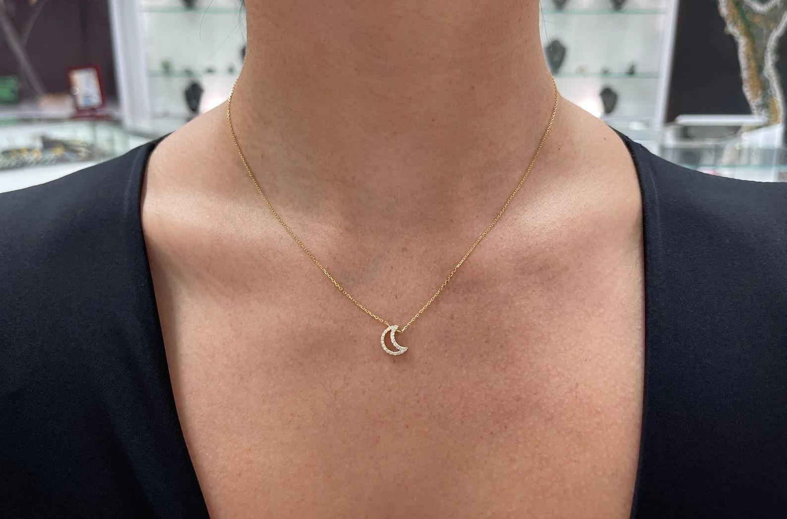 A petite, and gorgeous open crescent moon necklace; featuring numerous natural high-quality petite brilliant round cut diamonds. Pave set within a 14K gold setting, attached to an adjustable 14-18 inch cable chain necklace.

Setting Style: