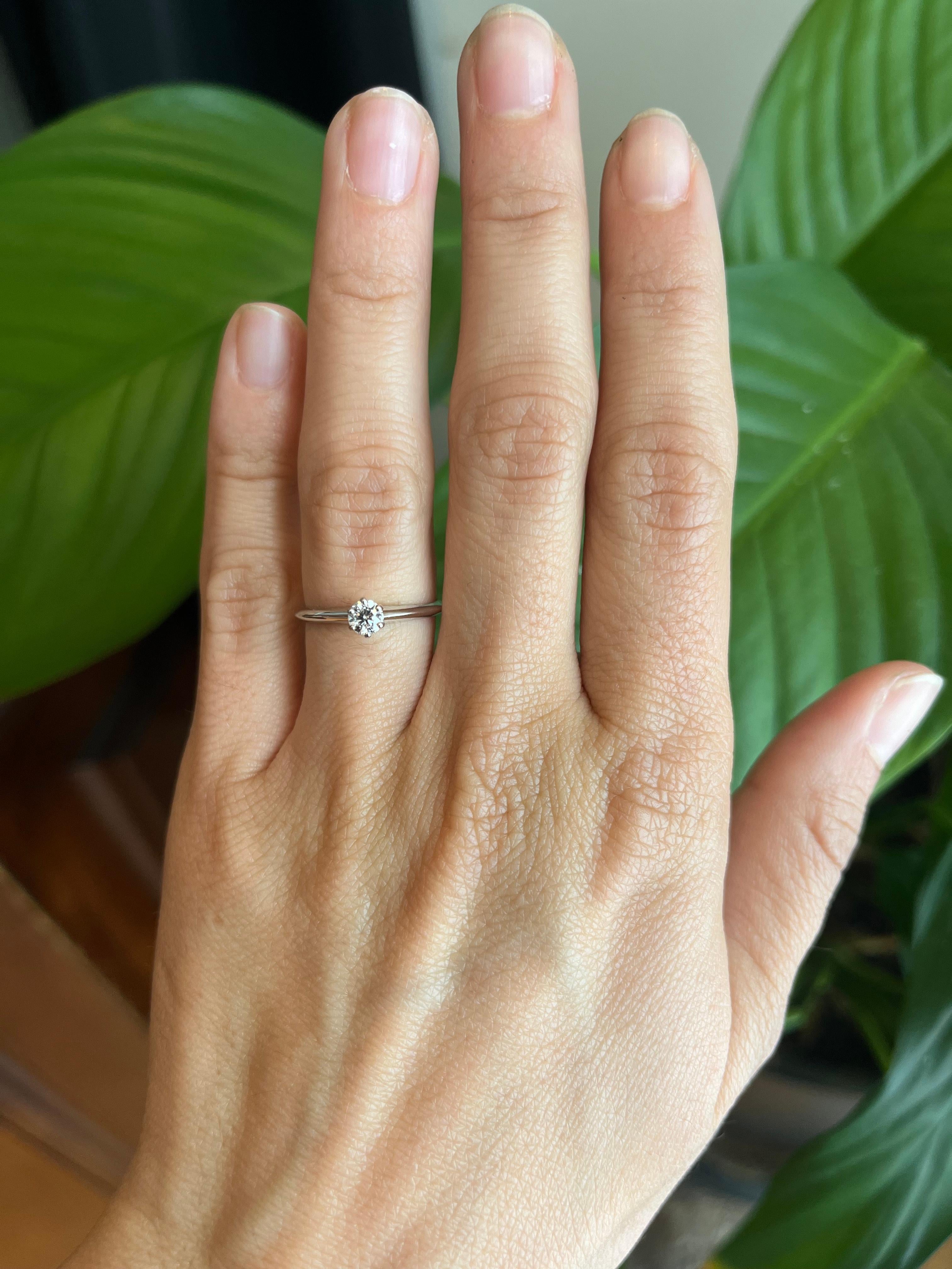 Bague de fiançailles solitaire en diamant de Tiffany & Co. en platine, ornée d'un diamant rond de taille brillant de 0,23 ct (pureté VS1, couleur G). La bande étroite présente un design en lame de couteau pour plus de raffinement. Un design à jamais
