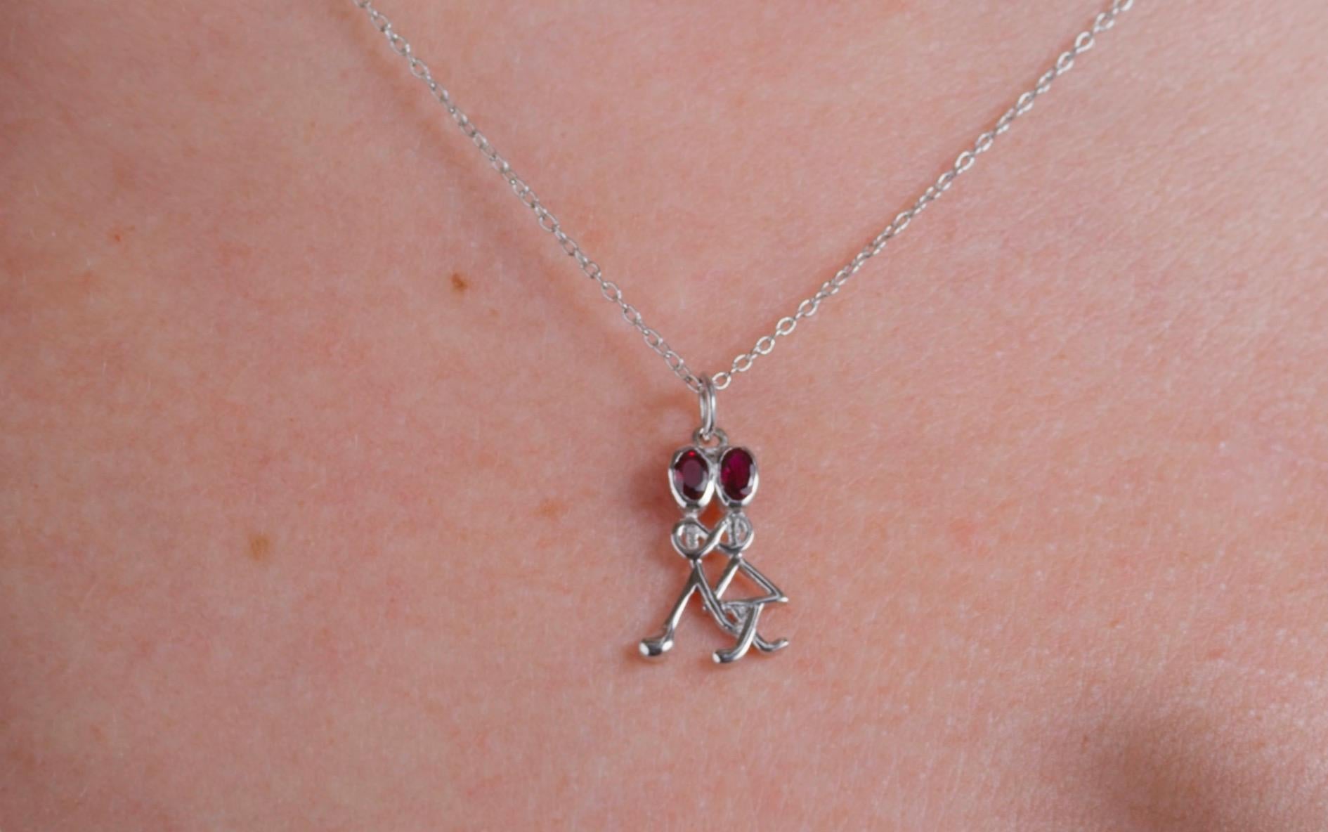 Collana con ciondolo a forma di bastone in argento Sterling Ruby da 0,24 carati.

Il ciondolo di questa collana raffigura due figure di bastoni (un uomo e una donna) con teste di rubino che si tengono per mano. Le loro braccia formano il simbolo