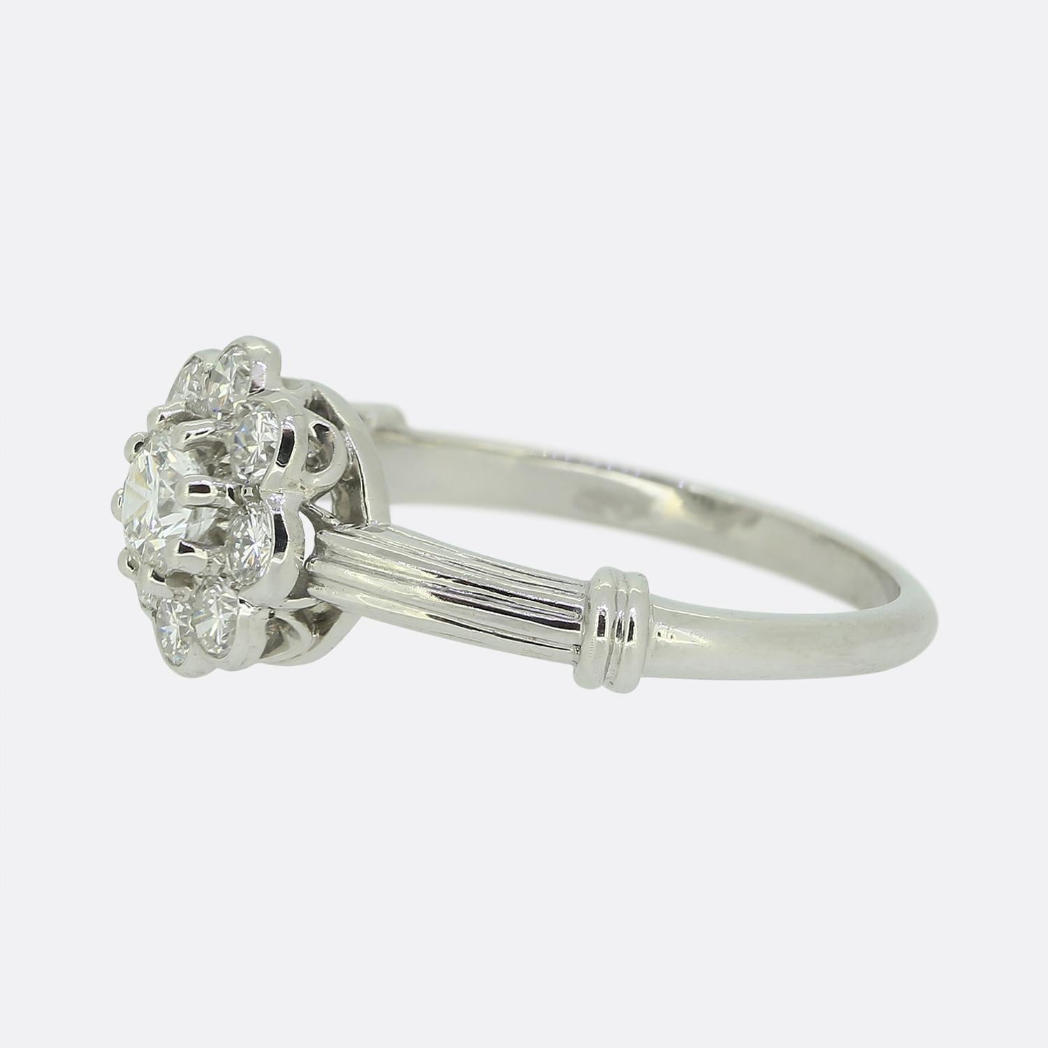 Hier haben wir einen wunderschönen Diamant-Gänseblümchen-Cluster-Ring. Im Mittelpunkt dieses Rings steht ein runder Diamant im Brillantschliff von 0,25 Karat, der leicht erhöht in der Mitte sitzt und von 8 weiteren Diamanten umgeben ist.

Zustand: