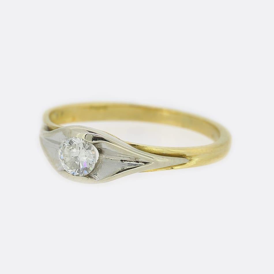 Se trata de un anillo solitario de diamantes de oro amarillo de 18 ct. El diamante central es una talla brillante redonda de 0,25 quilates y, aunque la banda del anillo es de oro amarillo, el diamante se asienta en una montura cóncava de oro