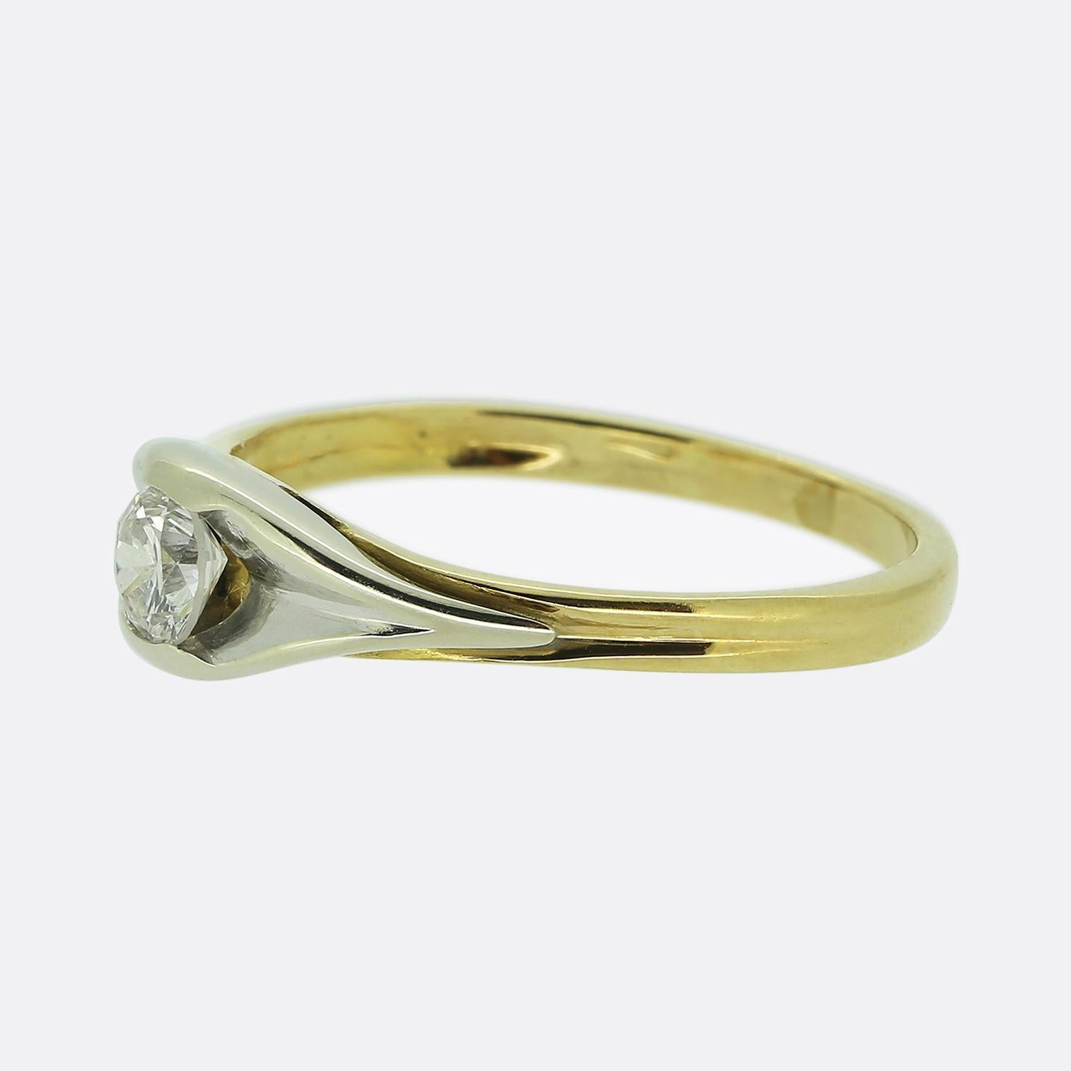 Here we have an 18ct yellow gold diamond solitaire ring. At the centre of the face we find a single 0.25 carat round brilliant cut diamond and although the band of the ring is yellow gold, this precious stone sits atop a concave white gold