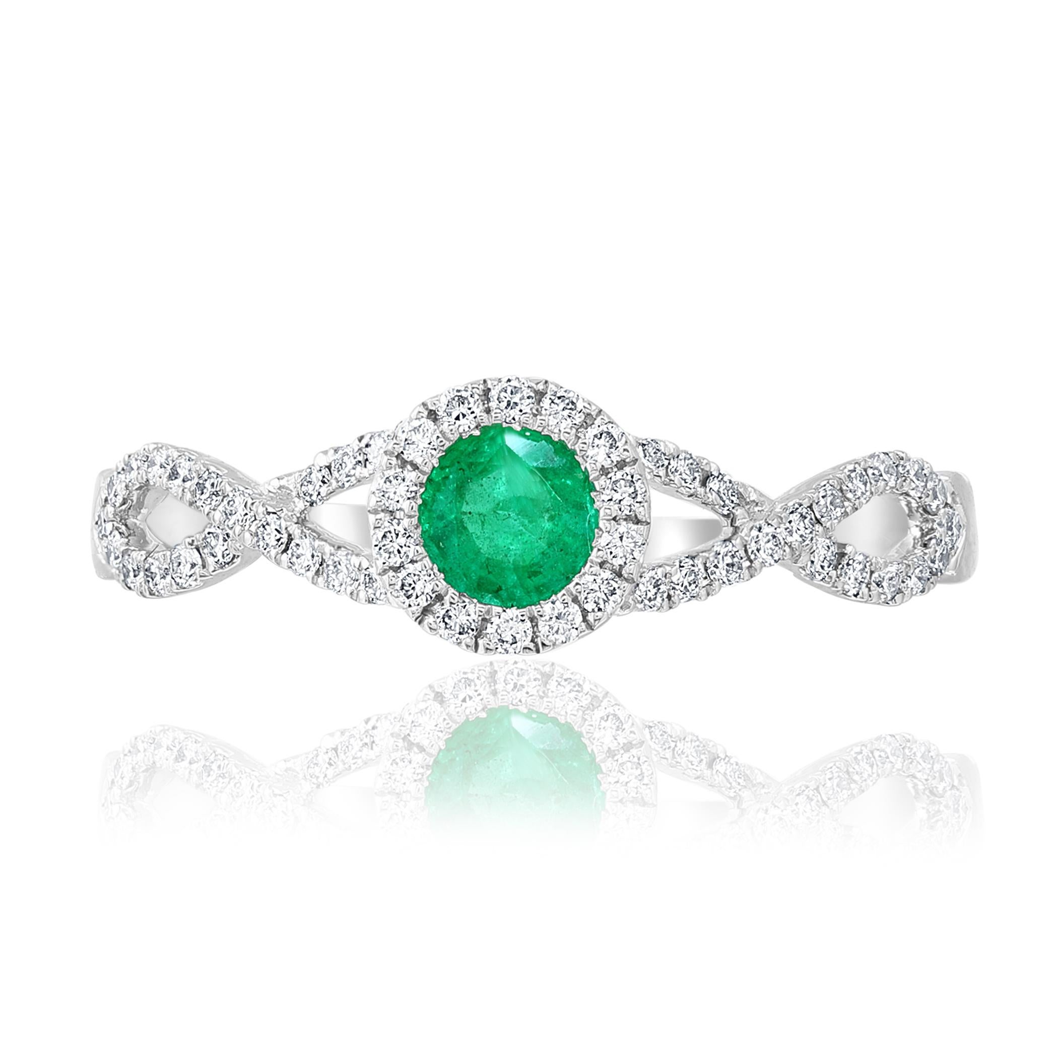A unique and chic piece of jewelry showcasing a gorgeous 0.25 carat round emerald  center stone that securely sit in a 4 prong setting. Surrounding the sapphire is a halo of round brilliant diamonds. Creative 14k white gold intertwined split 