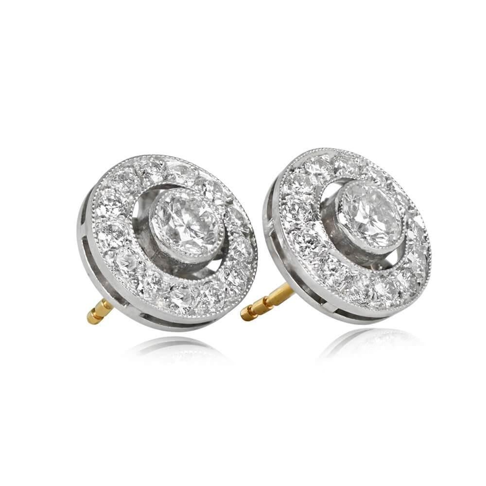 Indulge in the sheer elegance of these stunning earrings, adorned with two bezel-set round brilliant cut diamonds, each weighing approximately 0.25 carats. The captivating center diamonds are encircled by a sparkling halo of additional round